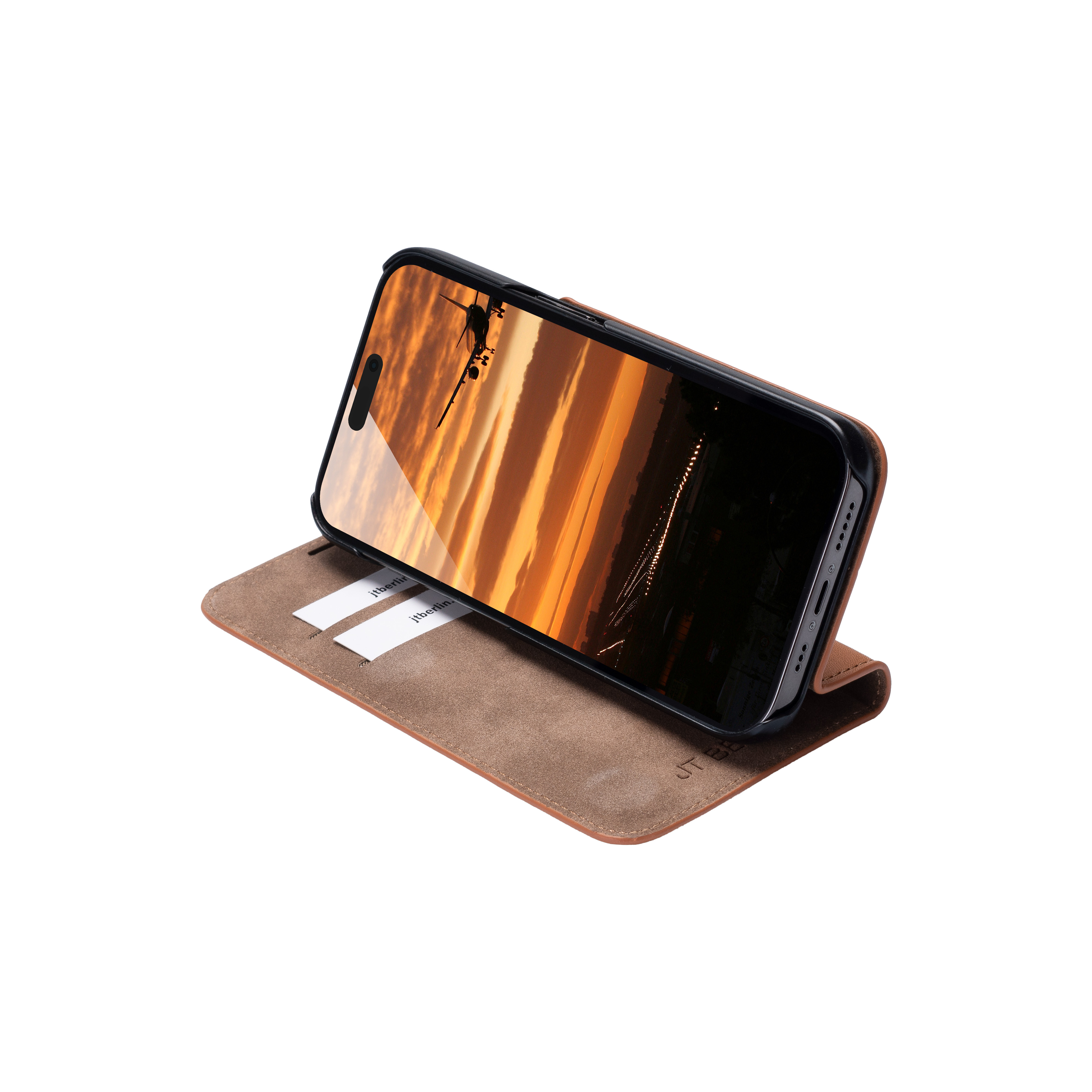 Smartphone dans un étui marron, ouvert, montrant une image de coucher de soleil. Fond blanc.