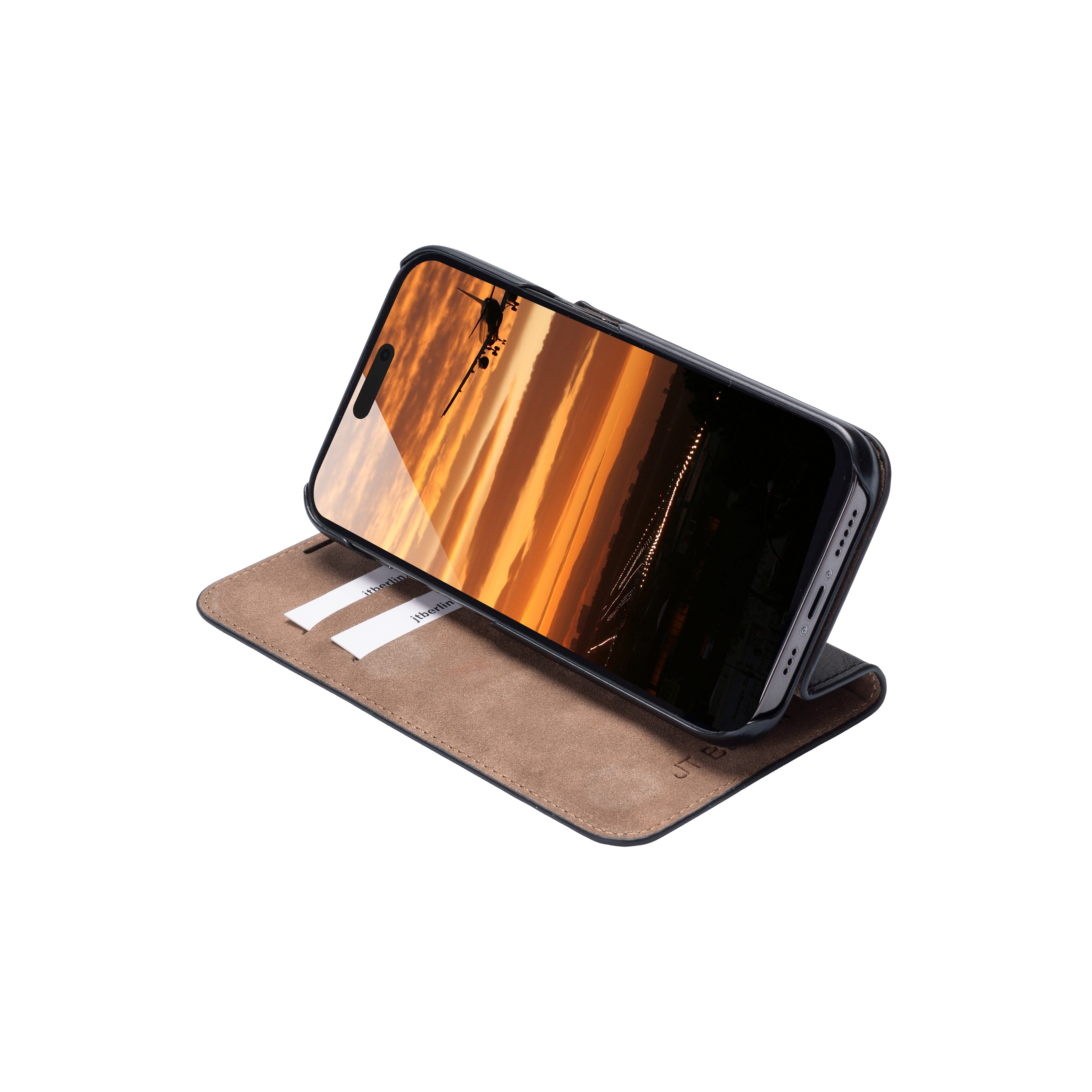 Telefono in una custodia a libro, che mostra un tramonto. La custodia è aperta su una superficie.