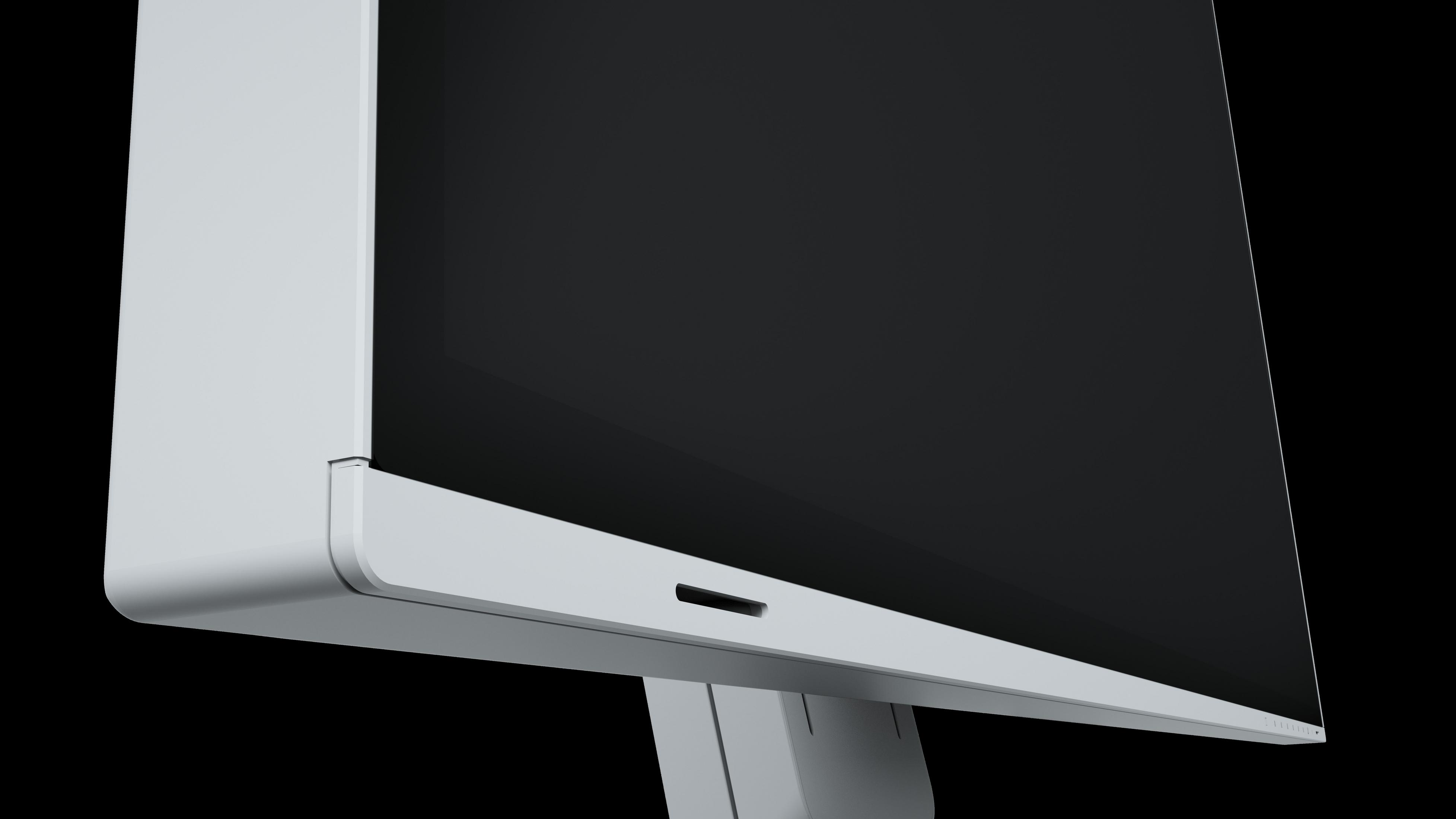 Primo piano di un monitor bianco, schermo nero e sfondo nero.