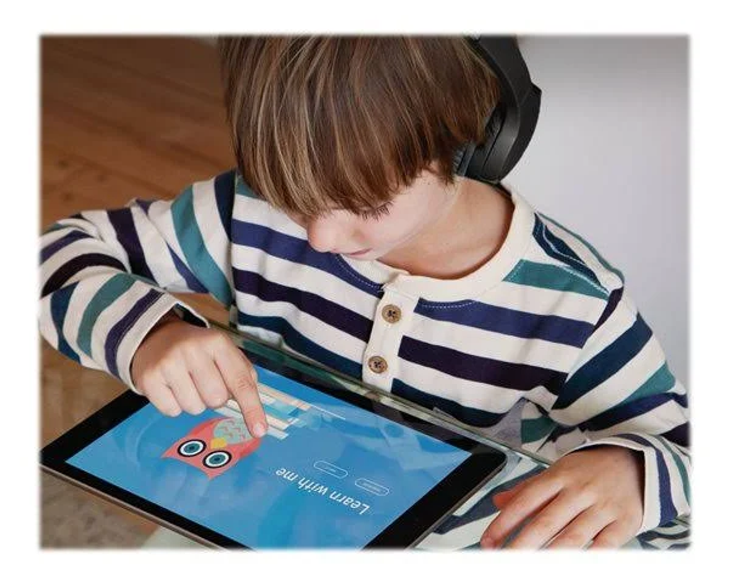 Ein Kind mit Kopfhörern interagiert mit einem Tablet, das eine Lern-App anzeigt.