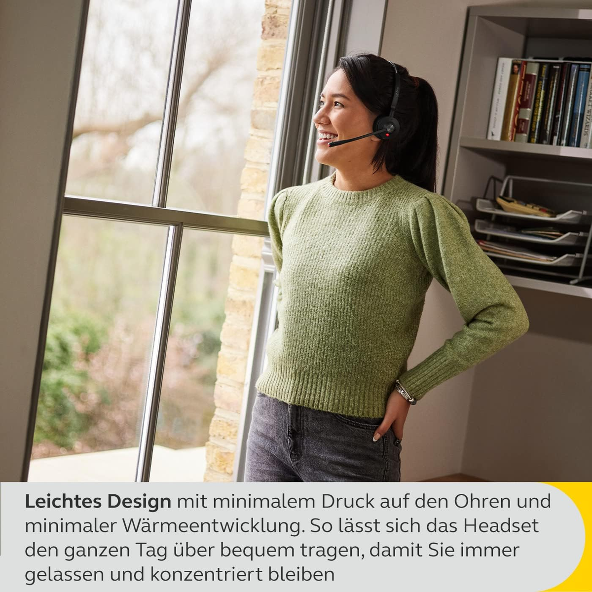 Eine Frau mit Headset blickt aus dem Fenster.