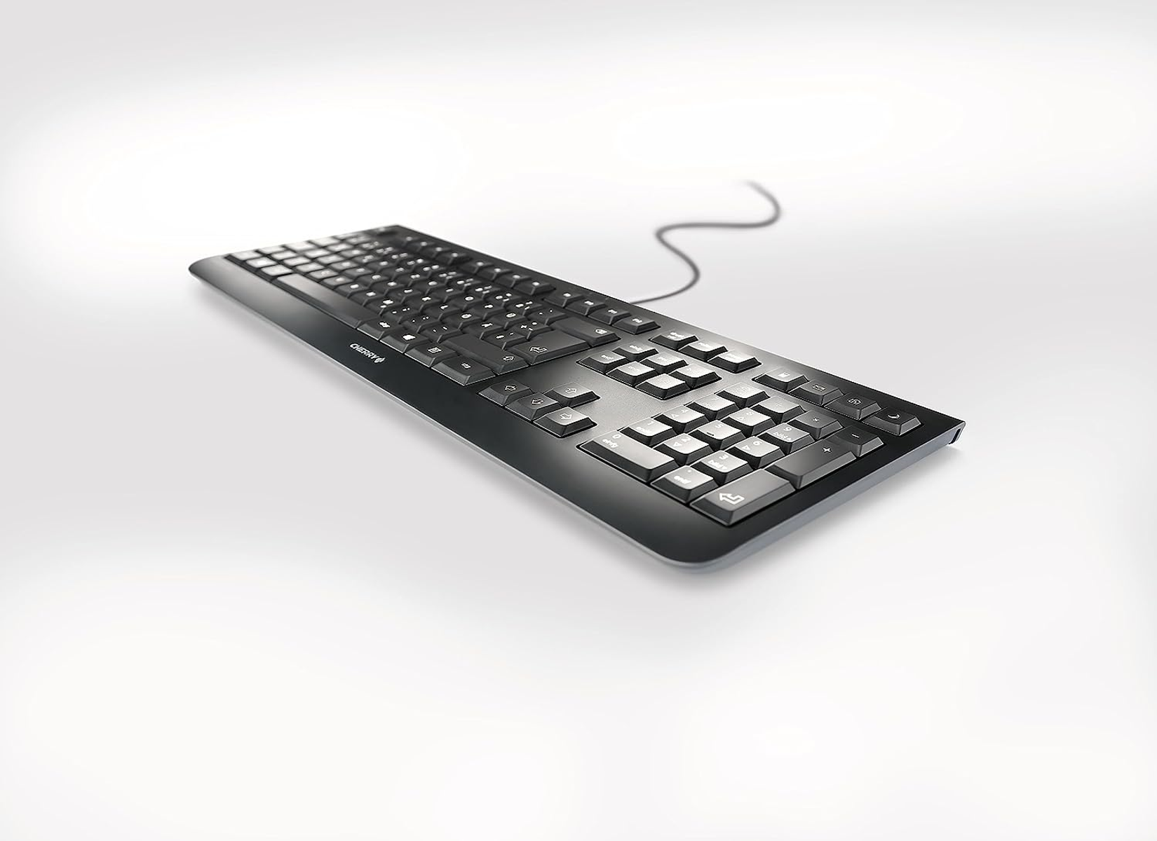 Schwarze Tastatur auf weißer Oberfläche. Die Tastatur ist von der Marke Cherry und hat viele Tasten.