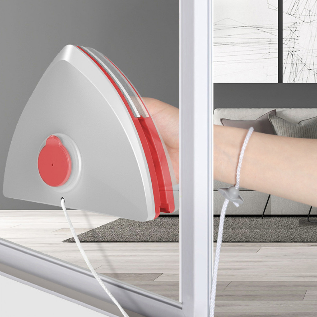 Ręka używająca myjki do okien z czerwonym uchwytem, z widokiem.