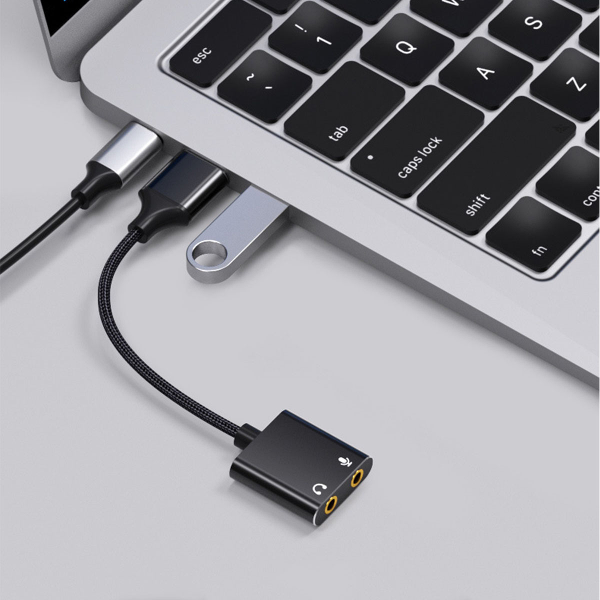 Laptop mit USB-C-Adaptern und einem schwarzen Audioadapter.