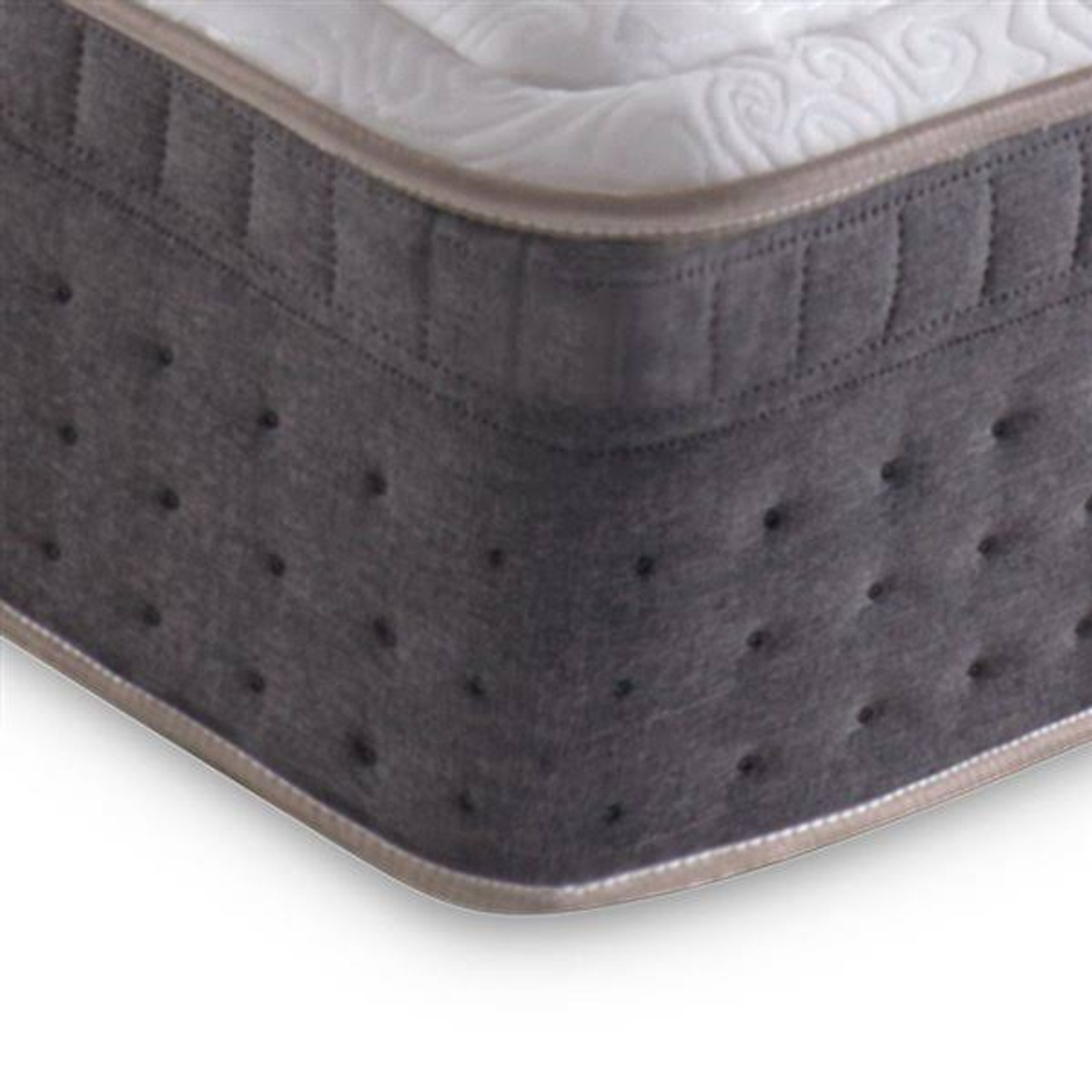 Zbliżenie na bok szarego materaca. Materac ma pikowany wzór i boczne przeszycia. Białe tło.