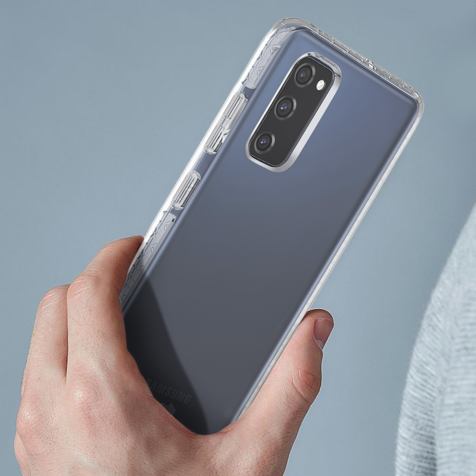 Hand die een blauw-paarse telefoon vasthoudt. De telefoon heeft een doorzichtige hoes. De achtergrond is blauw.