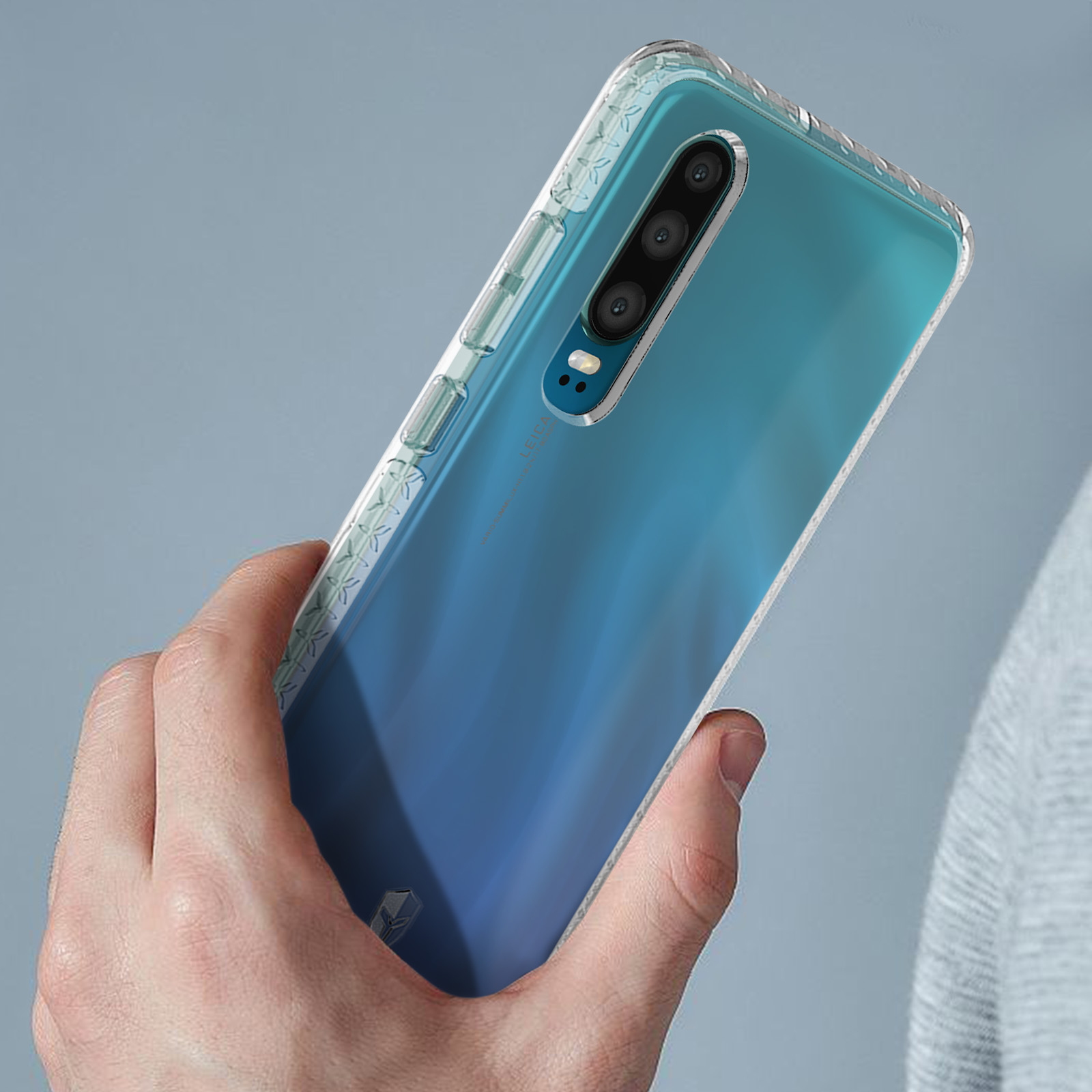 Hand die een telefoon vasthoudt met een transparante beschermhoes. De telefoon heeft een blauwe gradiënt achterkant.