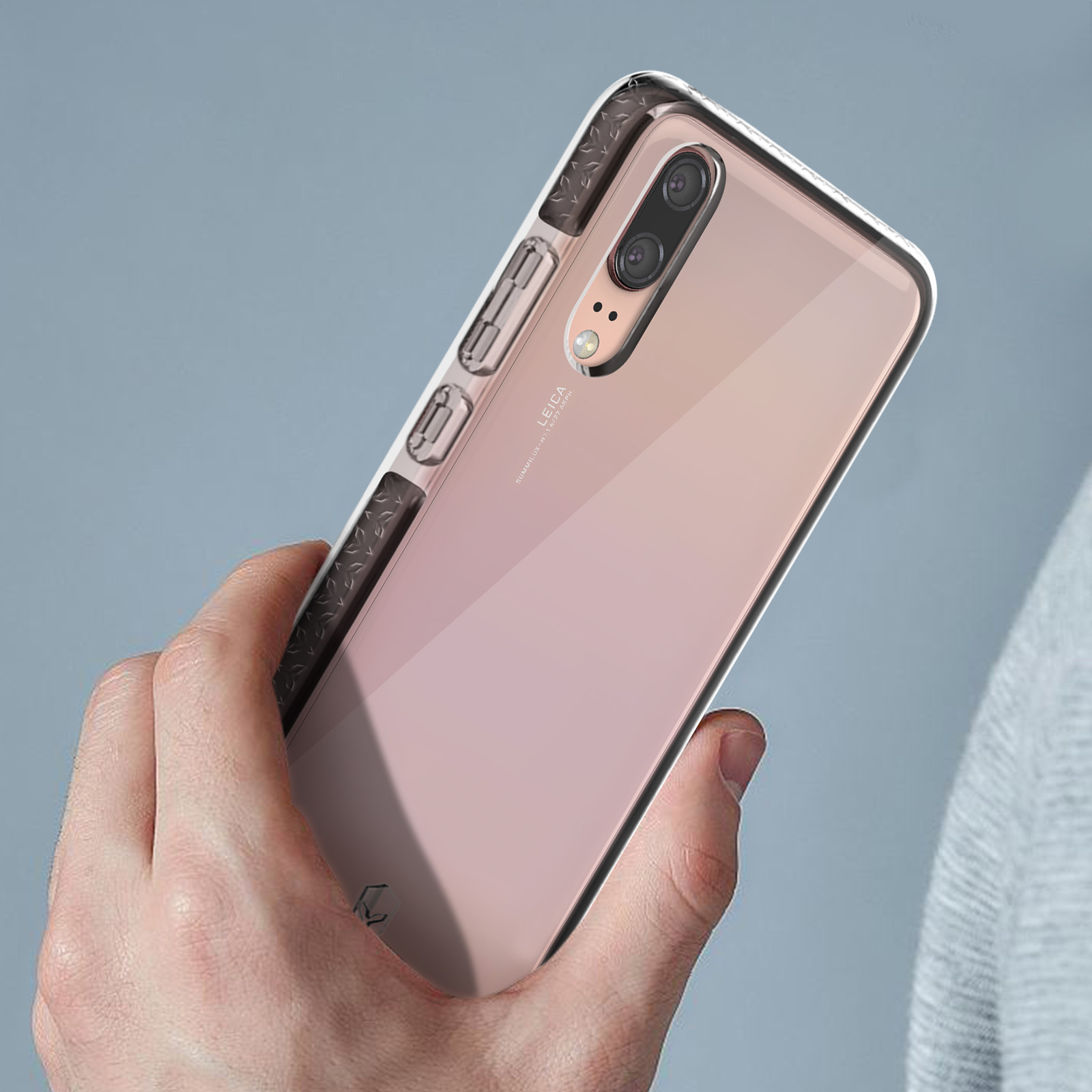 Een persoon die een roze smartphone vasthoudt in een beschermhoesje.