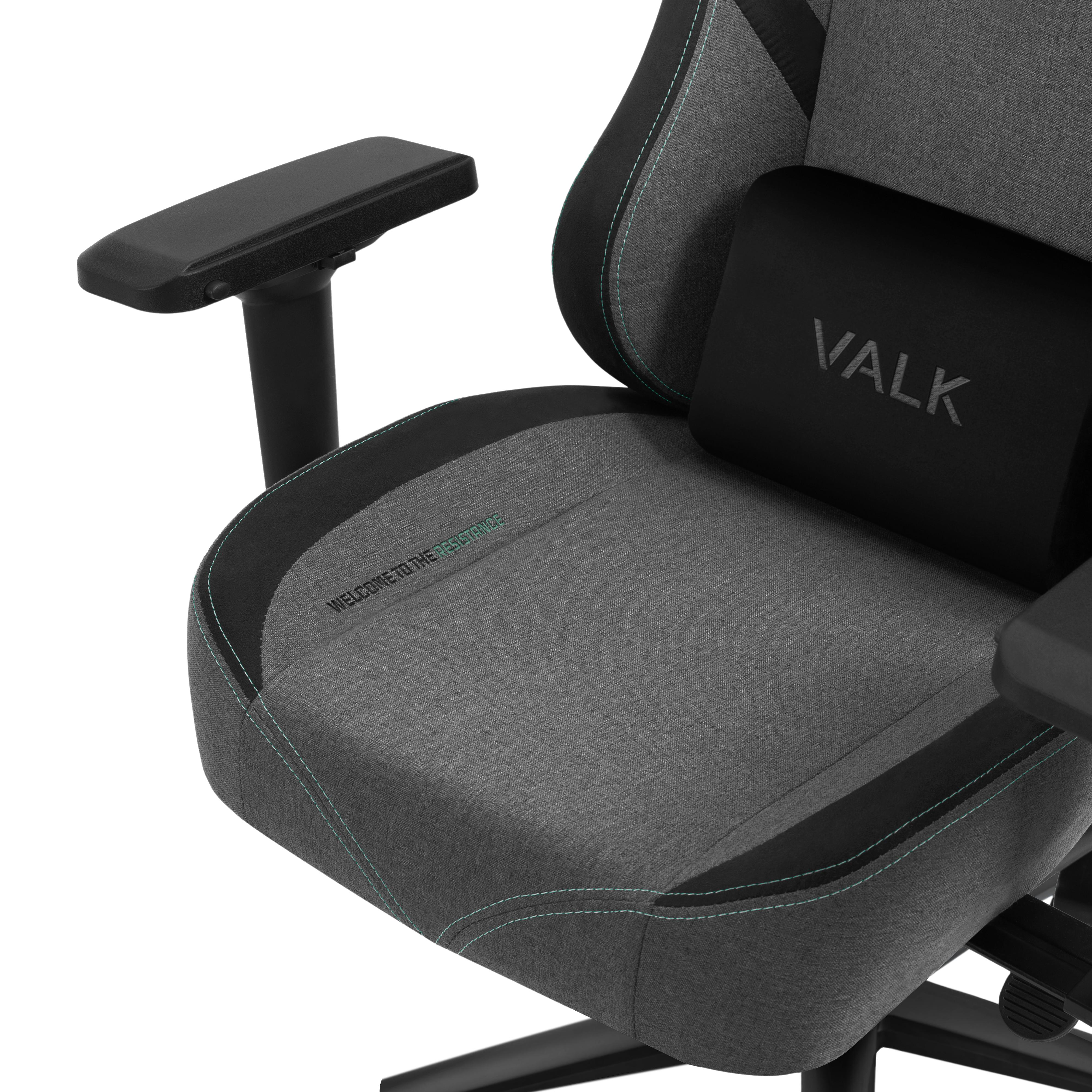 Una silla gaming con tela gris, detalles negros y un cojín trasero con 'VALK'.