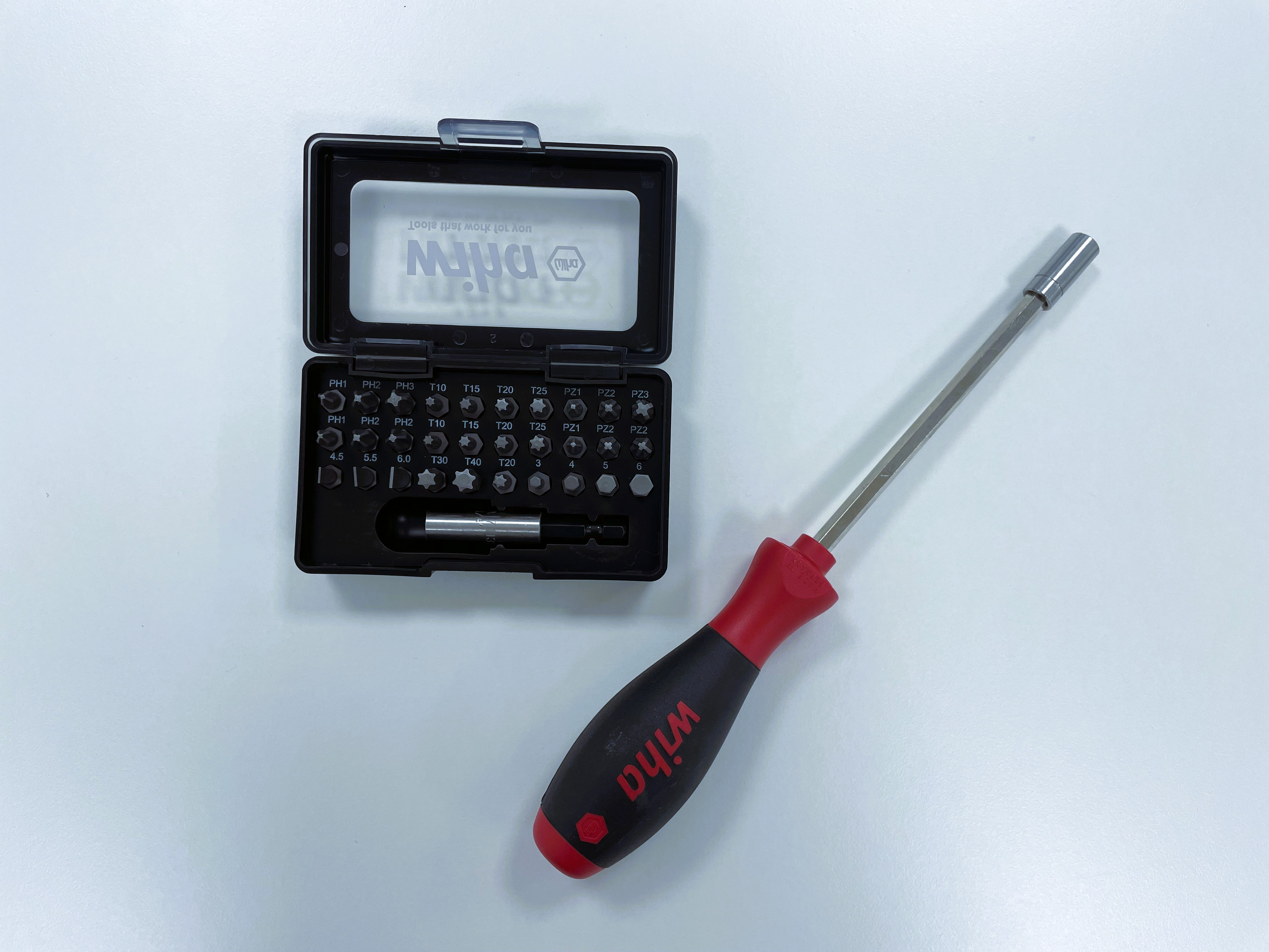 Schraubendreher-Set mit rotem Griff und Bits. Weißer Hintergrund.