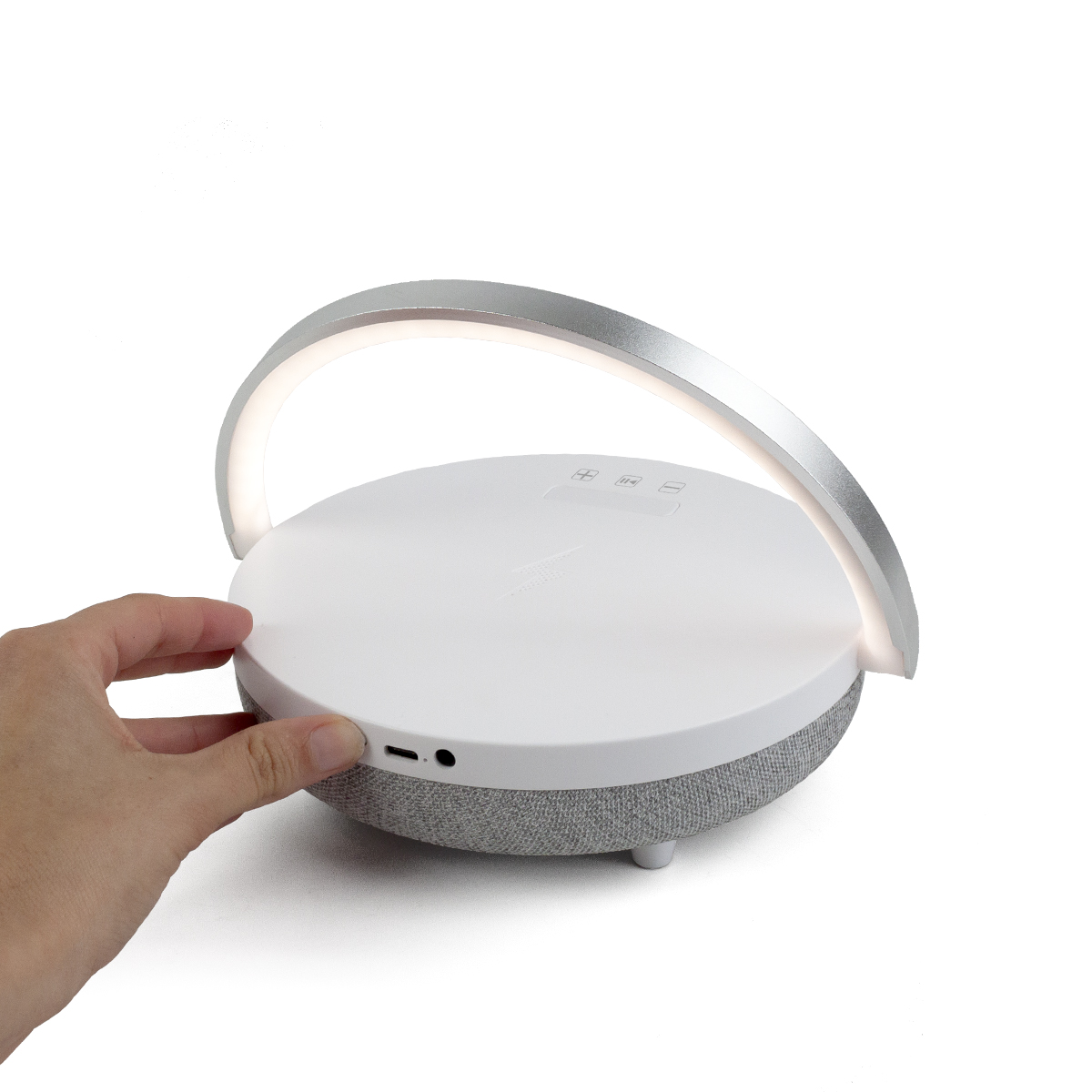 Biało-szary głośnik ze srebrnym uchwytem łukowym, dotykany dłonią.