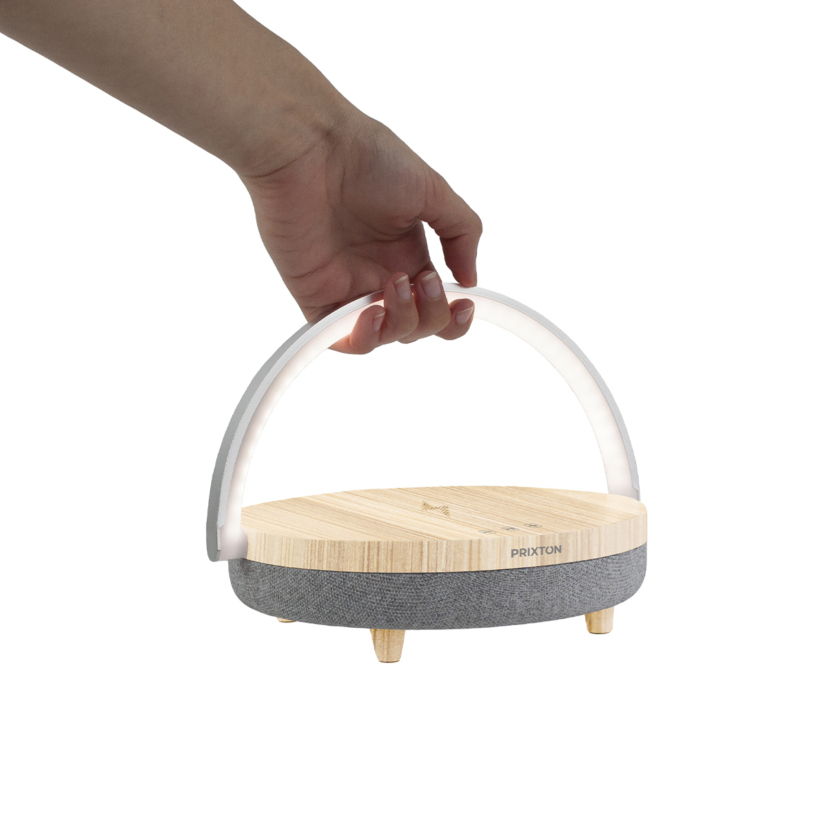 Osoba trzymająca białą, łukowatą lampę z drewnianą podstawą i szarą tkaniną, na białym tle.