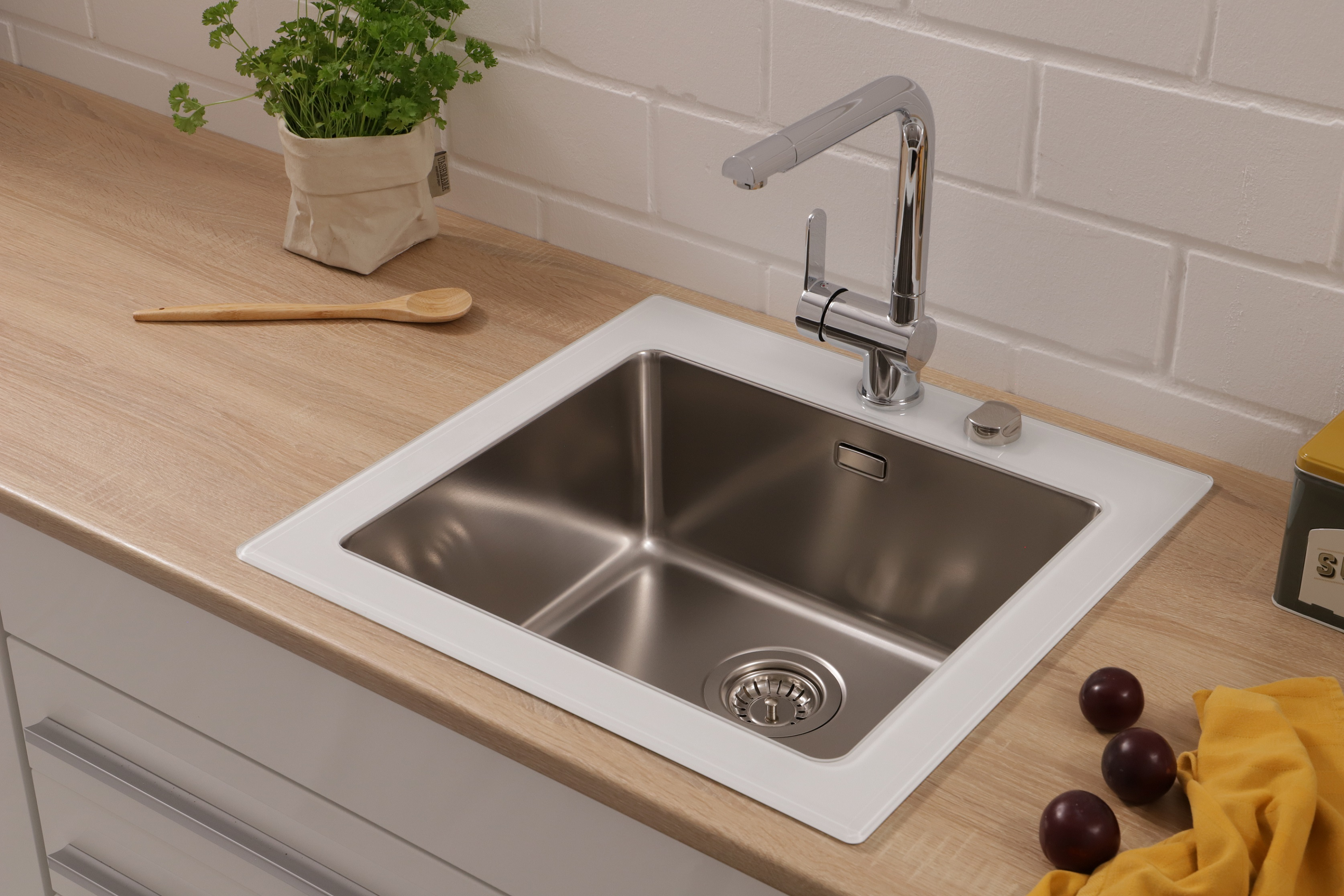 Edelstahl-Küchenspüle mit Wasserhahn und Holz-Arbeitsplatte.