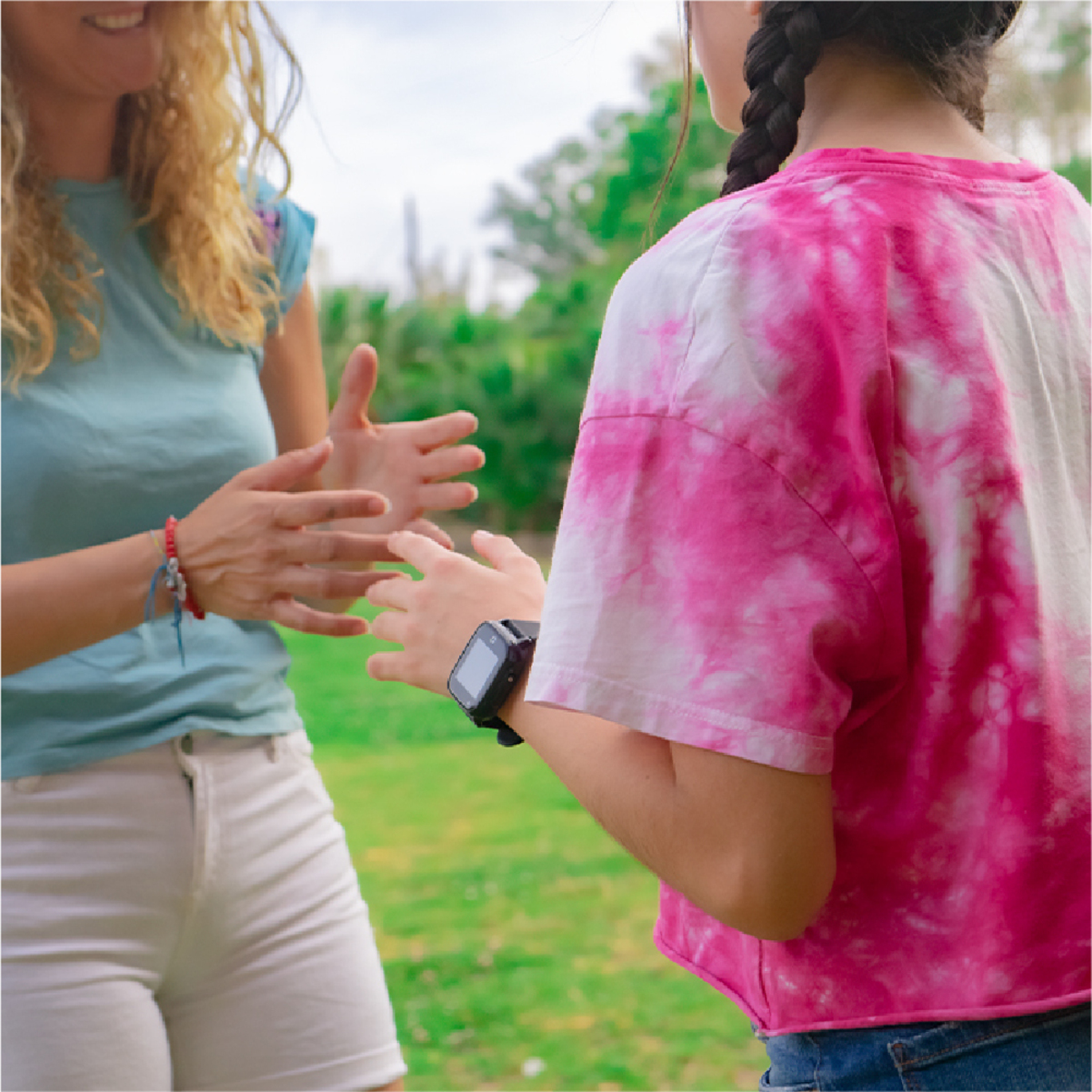 Dos personas aplaudiendo. Uno lleva camisa azul y pantalones cortos blancos, el otro una camisa rosa.