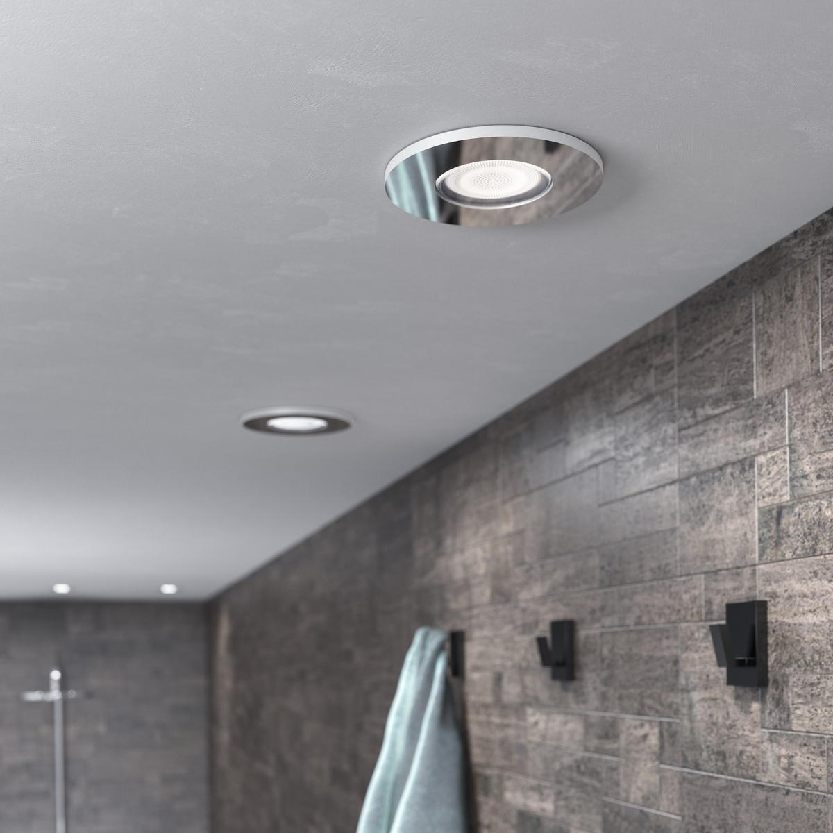 Techo de baño con dos luces empotradas y una toalla en un gancho. Pared de azulejos y tonos grises.