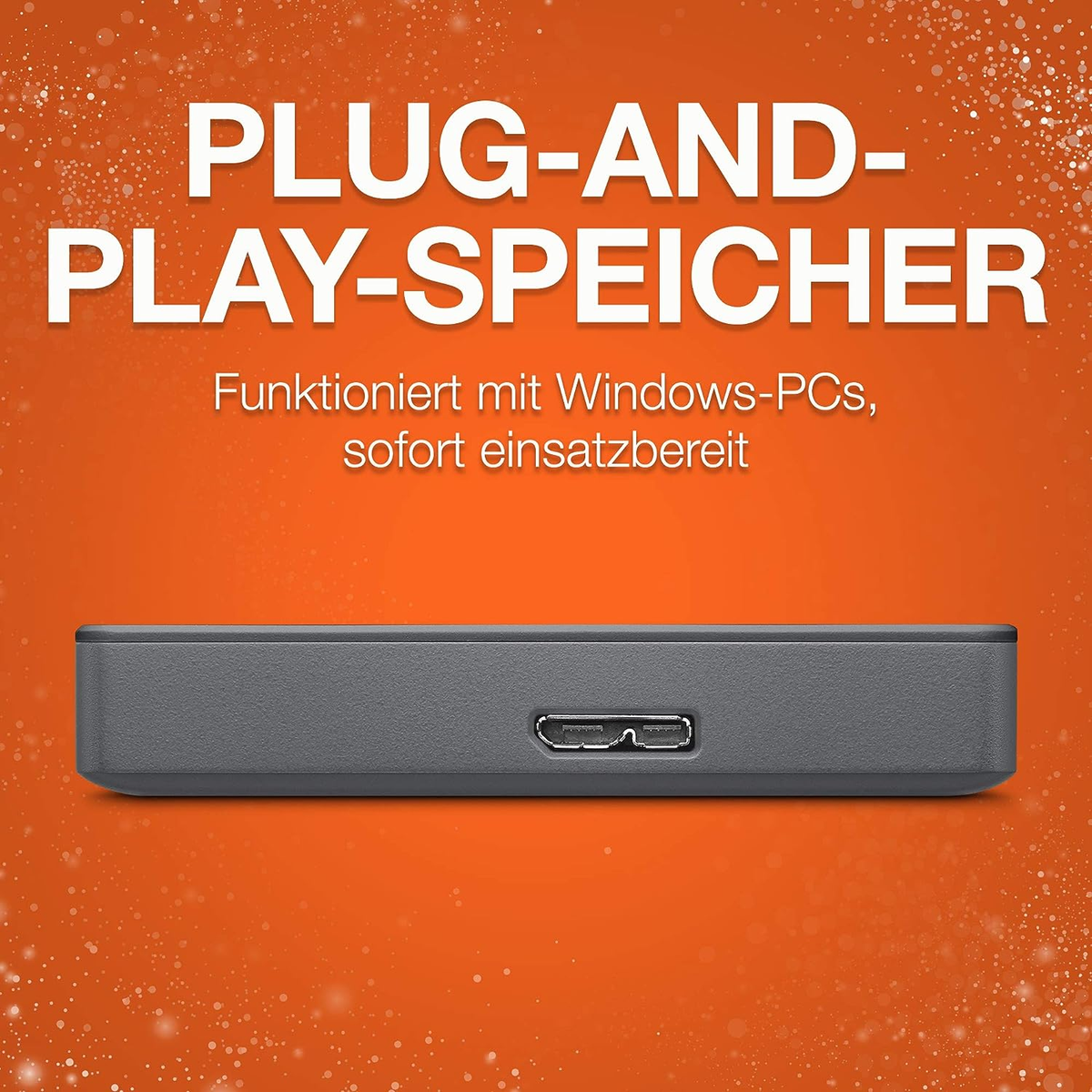 Szary, prostokątny zewnętrzny dysk twardy z portem USB na pomarańczowym tle z białymi kropkami.