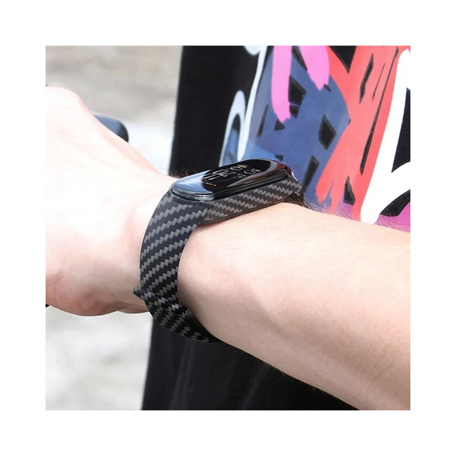 Handgelenk mit schwarz-grau gemusterter Smartwatch. Das Zifferblatt ist schwarz. Verschwommener Hintergrund.