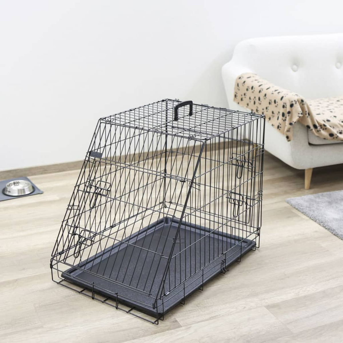 Schwarze Hunde-Metallbox mit einer Ablage, in einem Raum mit weißem Sofa und Teppich.