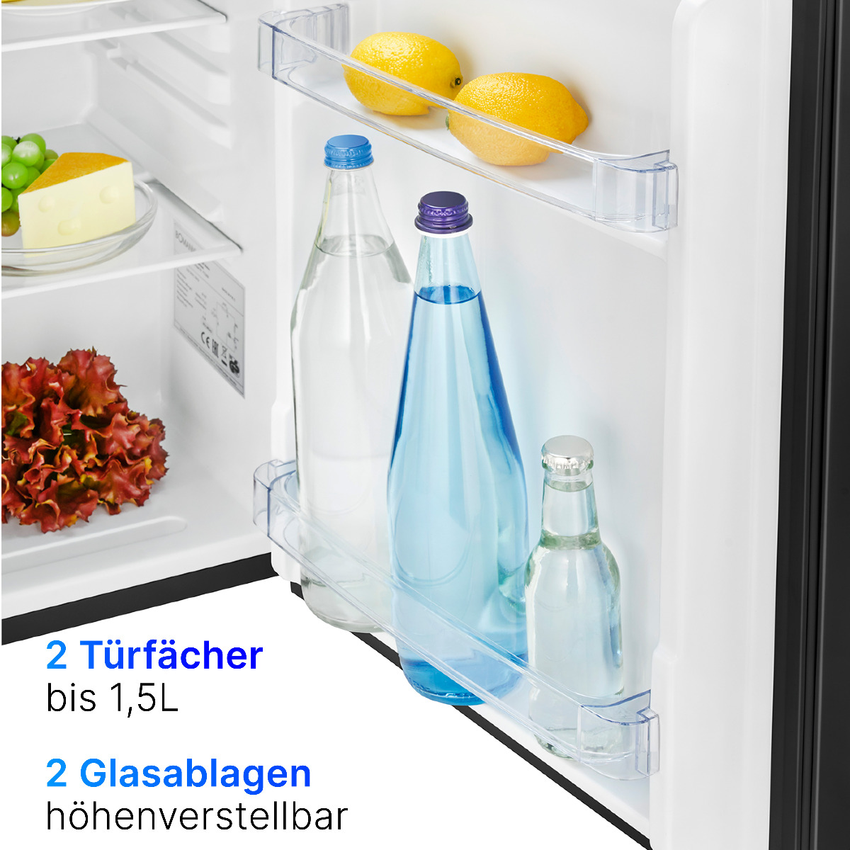 Kühlschrankinnenraum mit zwei Zitronen, zwei Wasserflaschen und einem kleinen Käseblock.