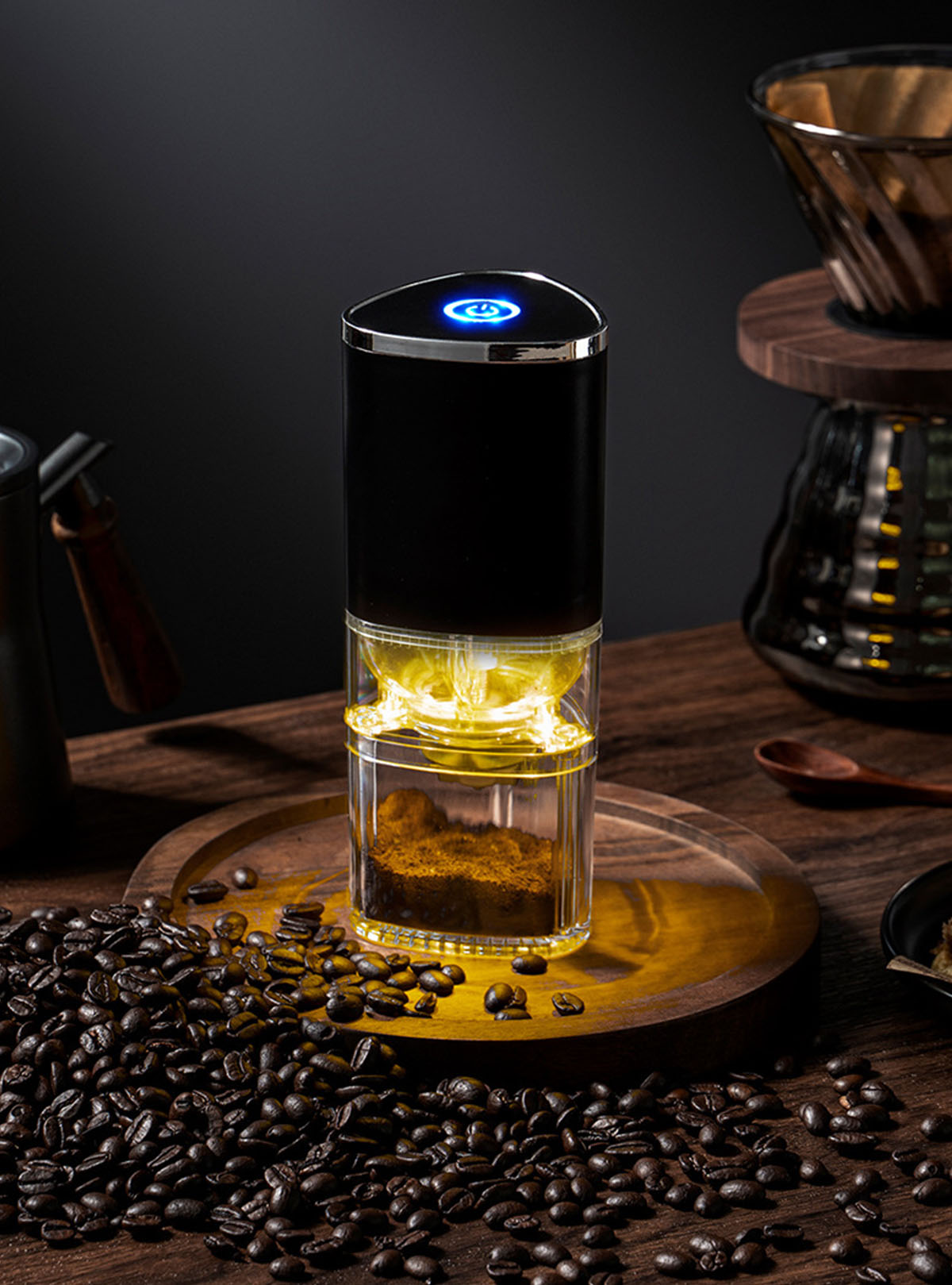 Schwarze Kaffeemühle mit Kaffeebohnen auf Holztablett. Dunkler Hintergrund.
