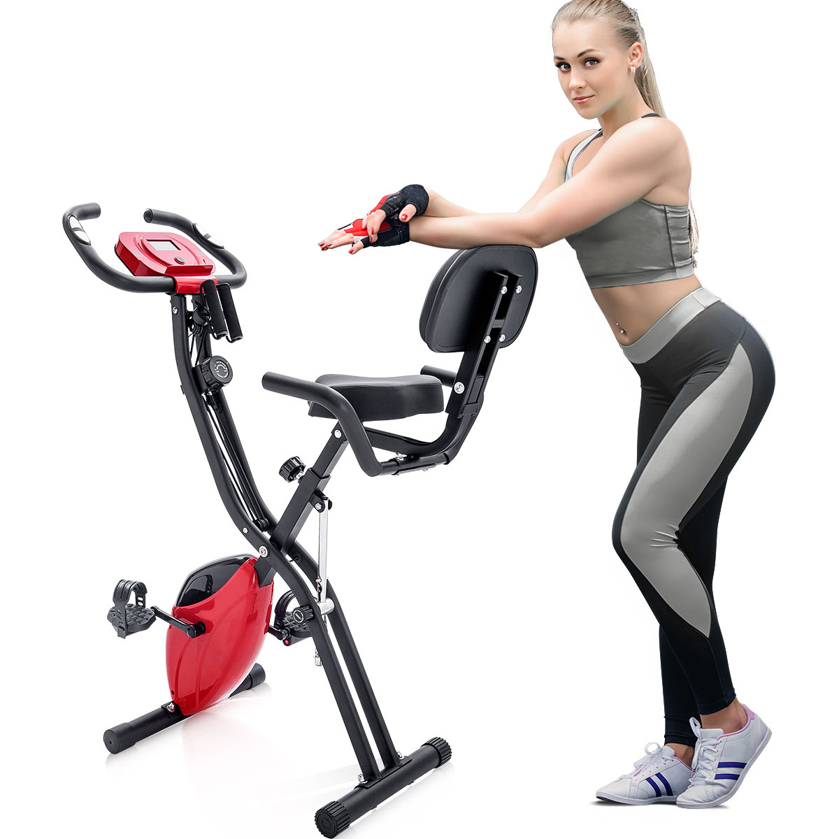 Blonde Frau lehnt sich an ein rotes stationäres Fahrrad. Sie trägt Sportkleidung und Schuhe.