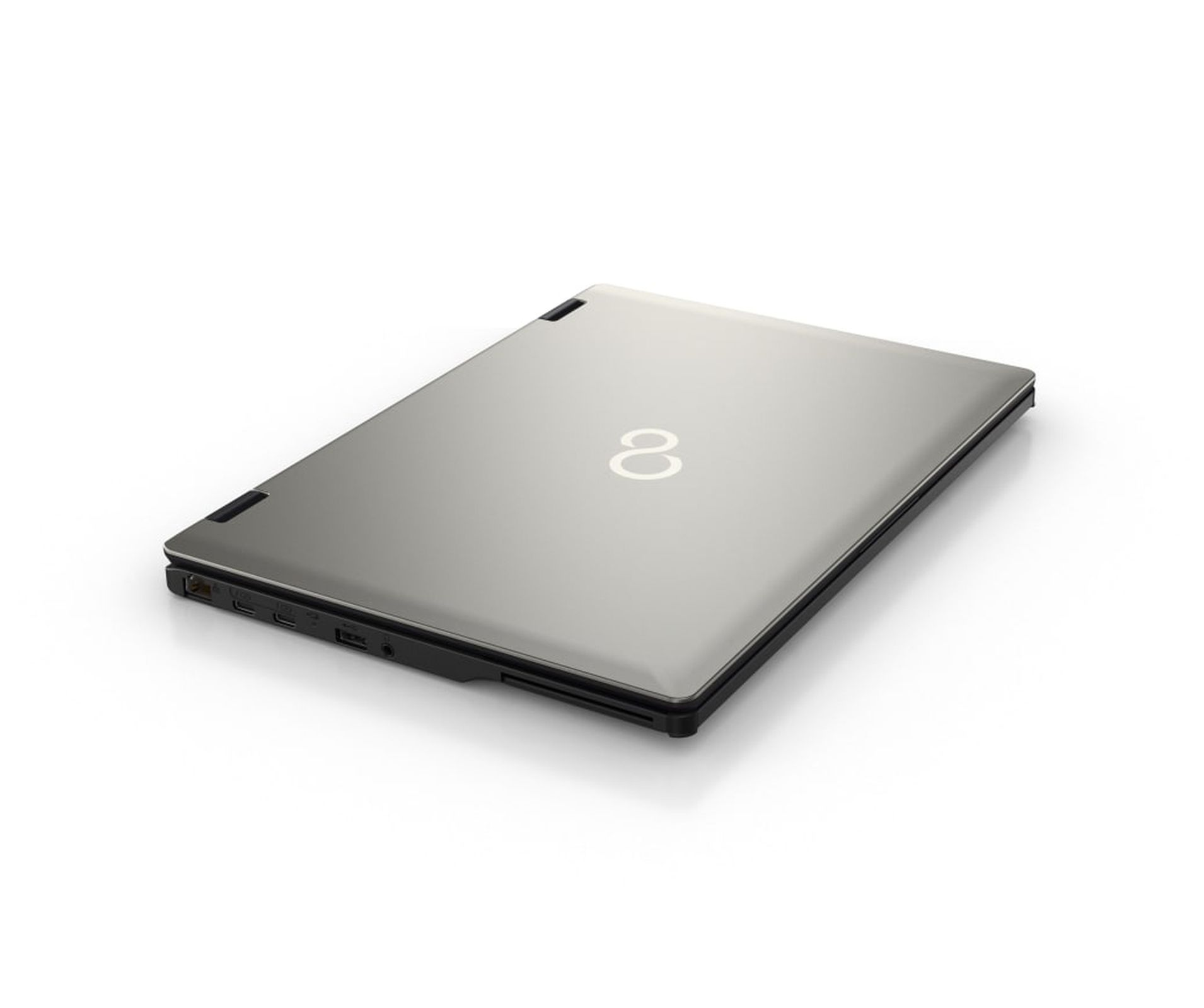 Srebrny laptop na białym tle. Laptop jest zamknięty. Logo znajduje się na górze.