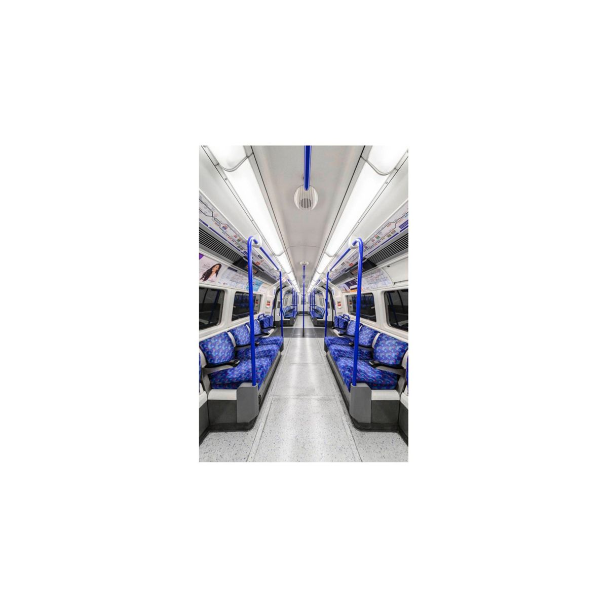Innenraum einer U-Bahn mit blauen Sitzen und Handläufen, weißer Decke und grauem Boden.