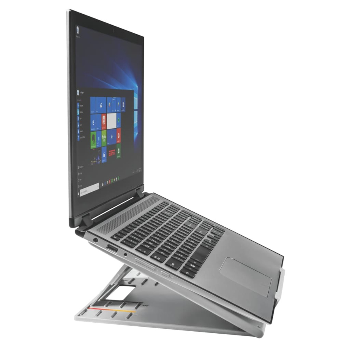 Laptop su supporto argento. Schermo aperto, desktop Windows. Vista angolata.