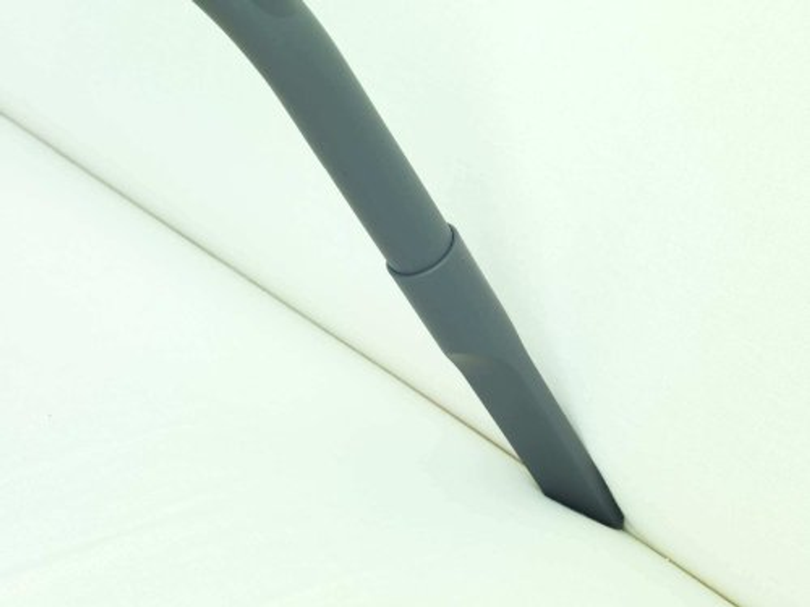 Dysza odkurzacza oparta o białą ścianę.