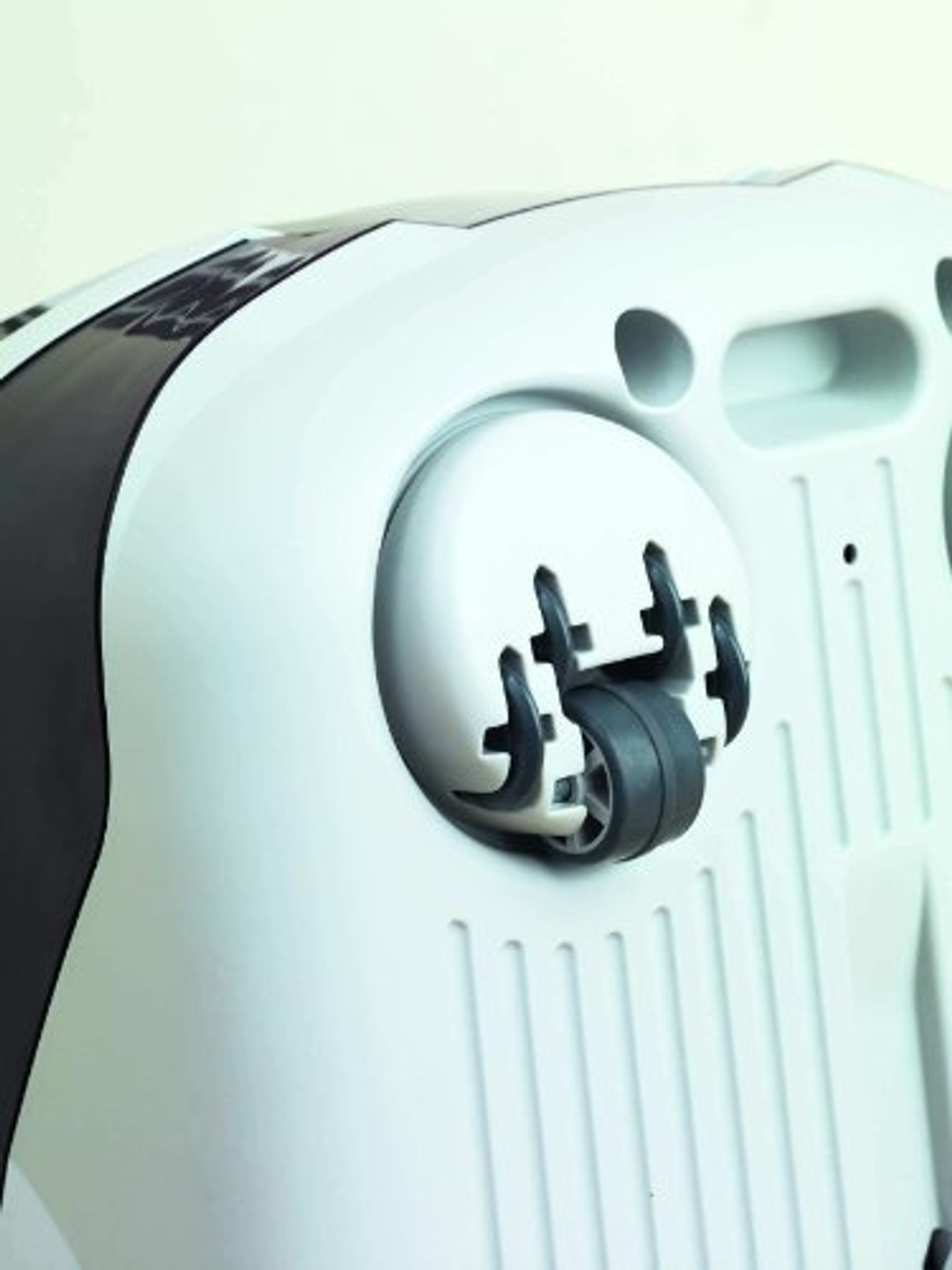 Biało-czarna podstawa odkurzacza z kołami. Koła są czarne.