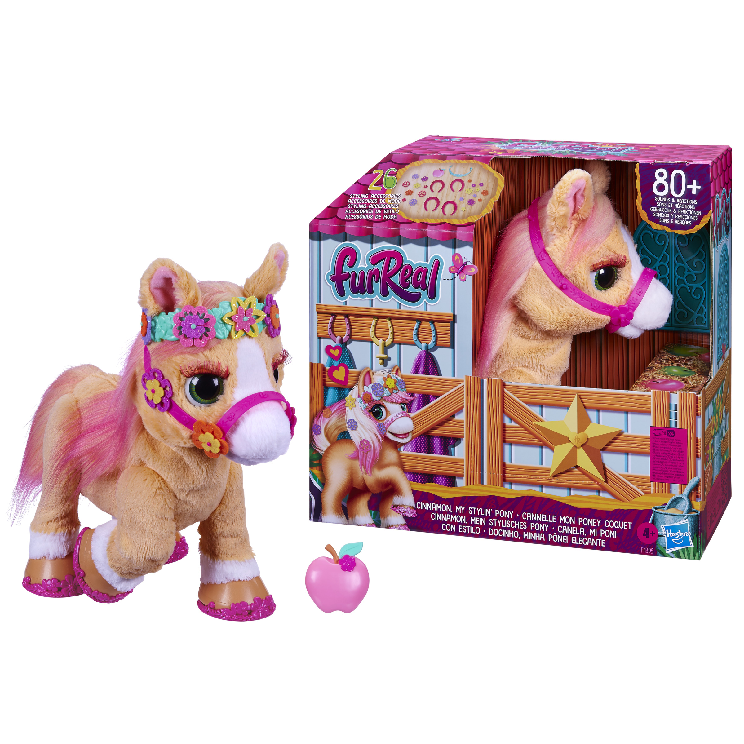 Caballo de juguete con melena rosa, flores y una manzana rosa, con caja de fondo.