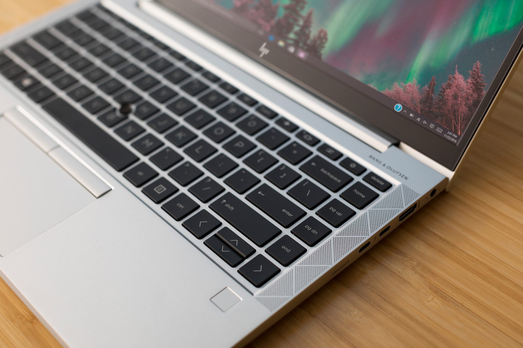 Nahaufnahme einer silbernen Laptop-Tastatur mit einem Bildschirm, der einen Desktop anzeigt.