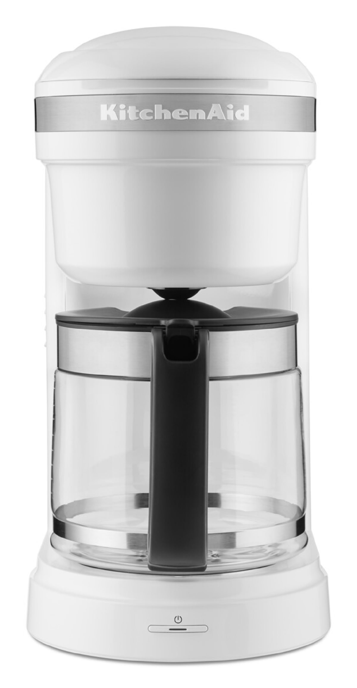 Beyaz KitchenAid kahve makinesi. Şeffaf cam sürahi, siyah sap. Beyaz zemin.