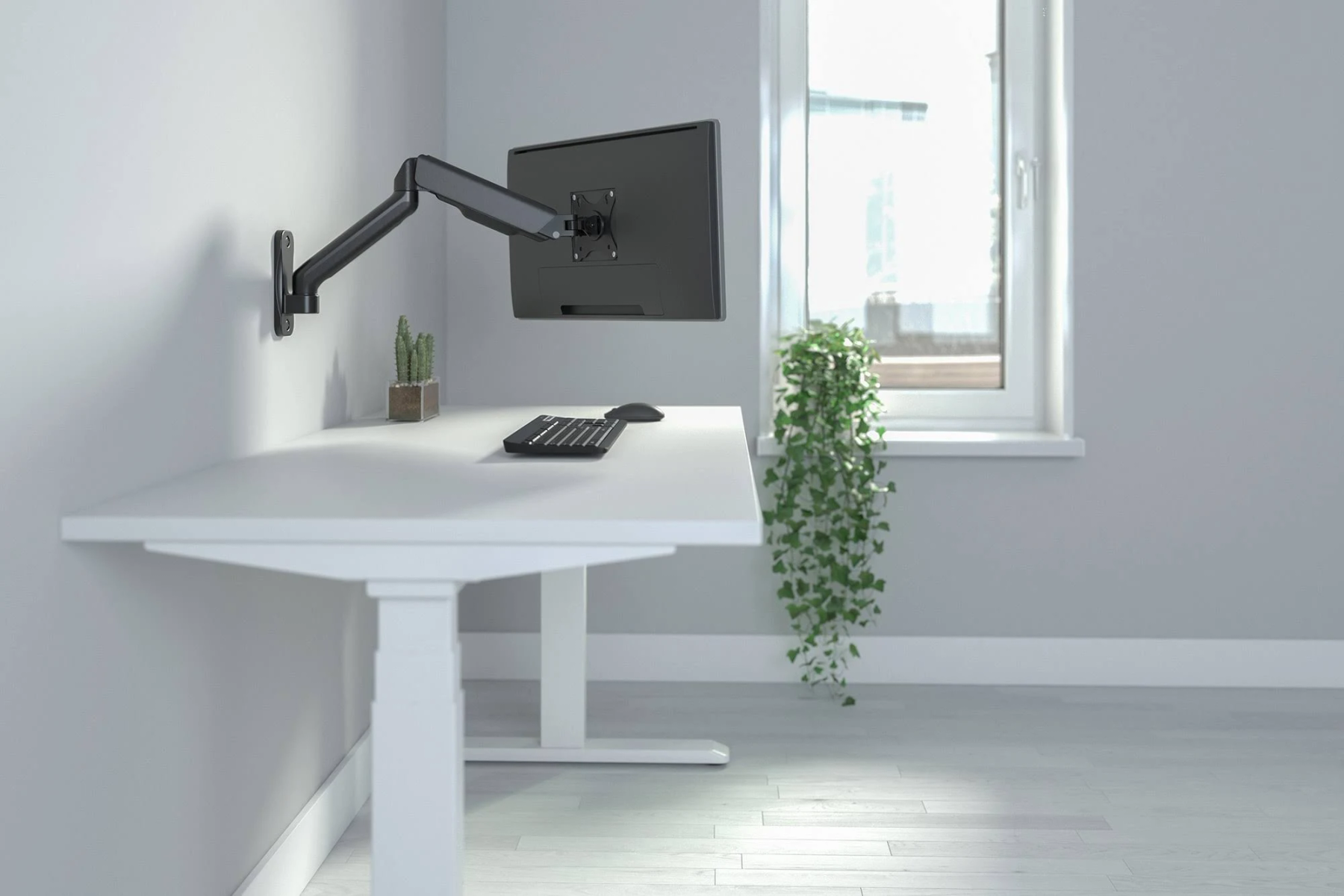 Ein weißer Schreibtisch mit einem Monitor an einem Wandarm, Tastatur und Maus, mit Fenster.