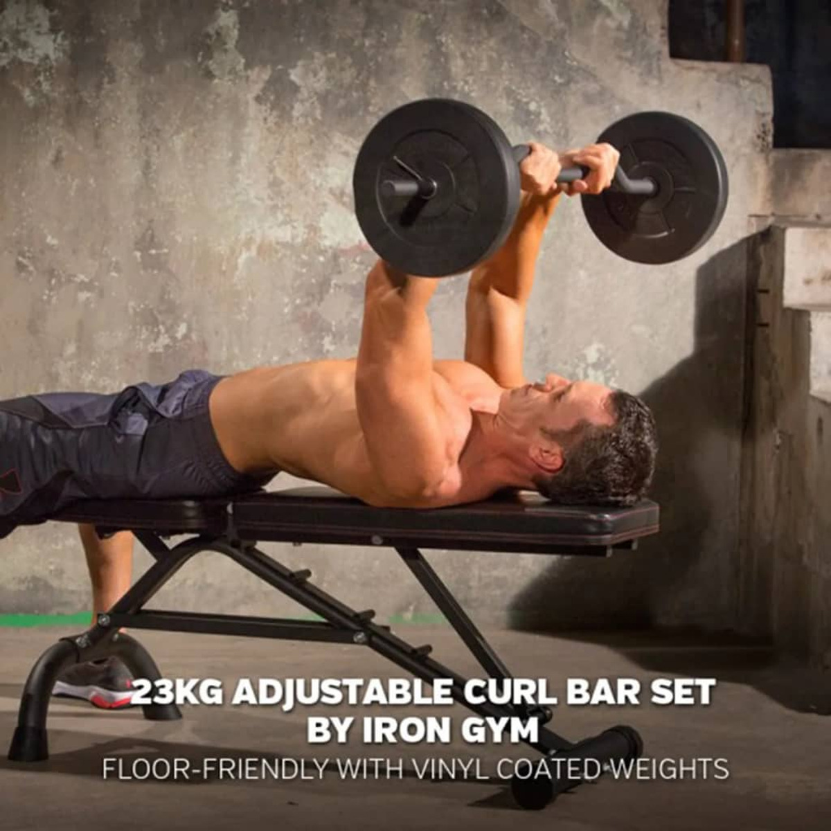 Ein Mann liegt auf einer Bank und hebt eine Langhantel mit Gewichten. Text: 23KG ADJUSTABLE CURL BAR SET.