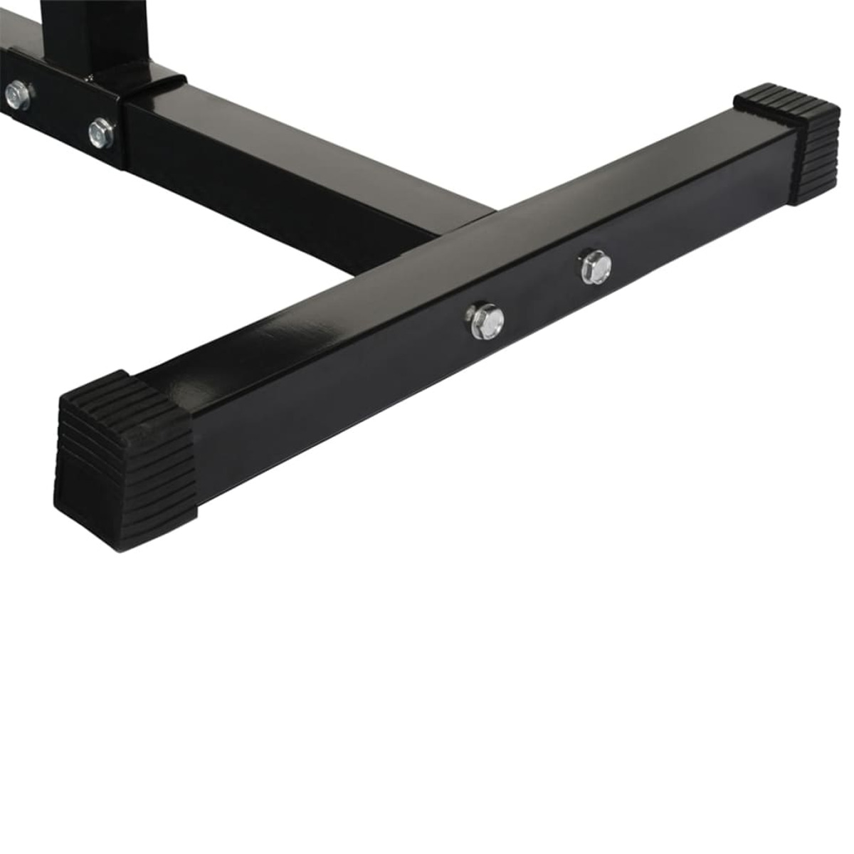 Zbliżenie czarnej podstawy ławki do ćwiczeń na białym tle. Zawiera śruby i gumowe nóżki.