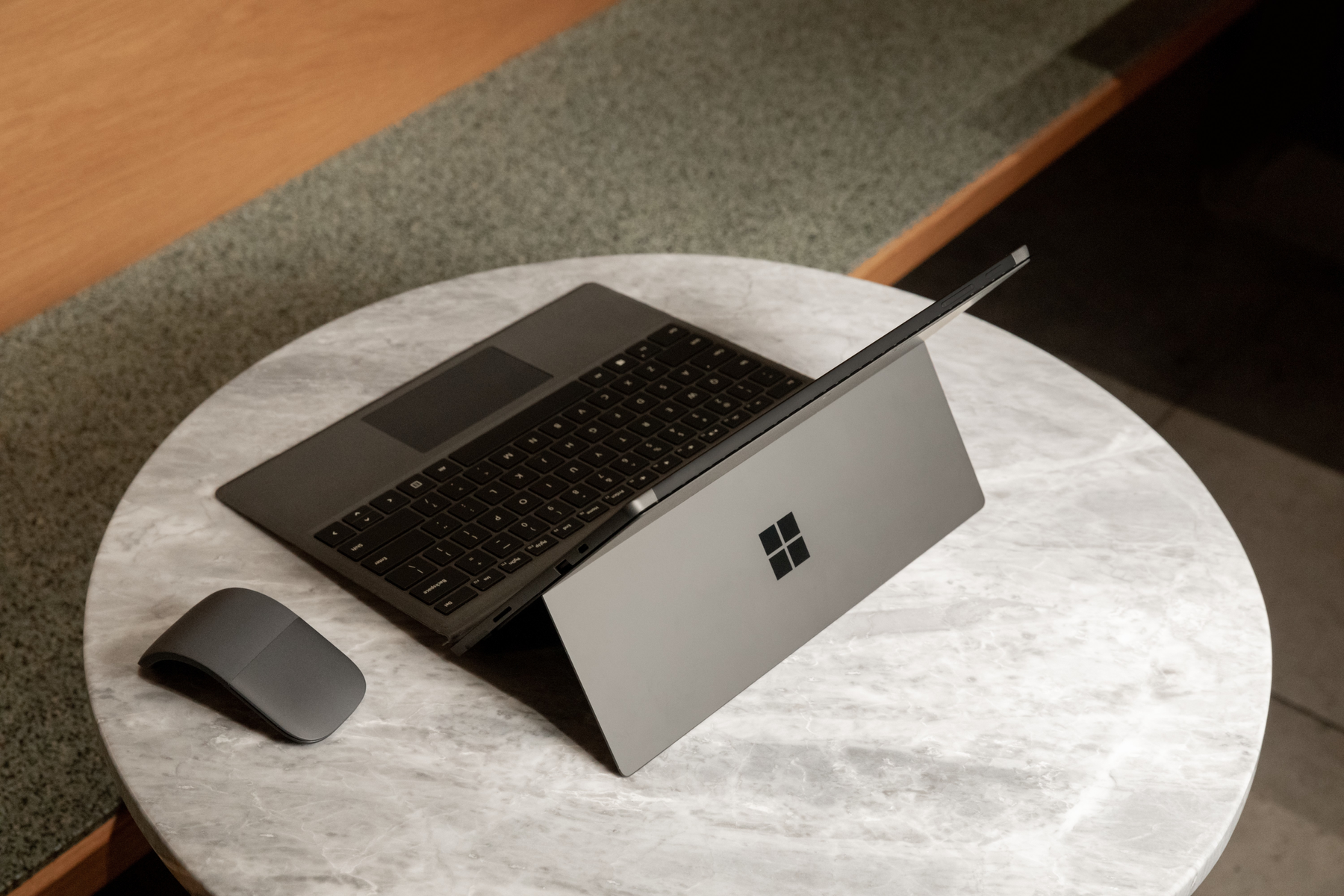 Un laptop aperto su un tavolo con un mouse accanto, su sfondo bianco.