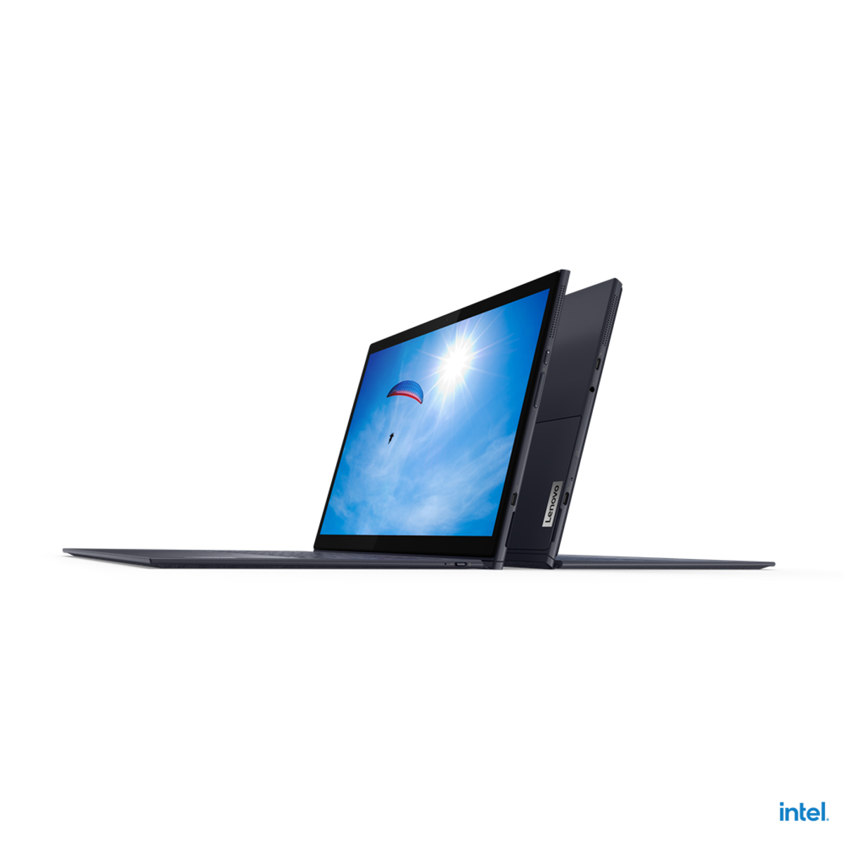 Laptop geöffnet, Bildschirm zeigt sonnigen Himmel mit Gleitschirm. Lenovo-Logo und Intel-Logo sichtbar.