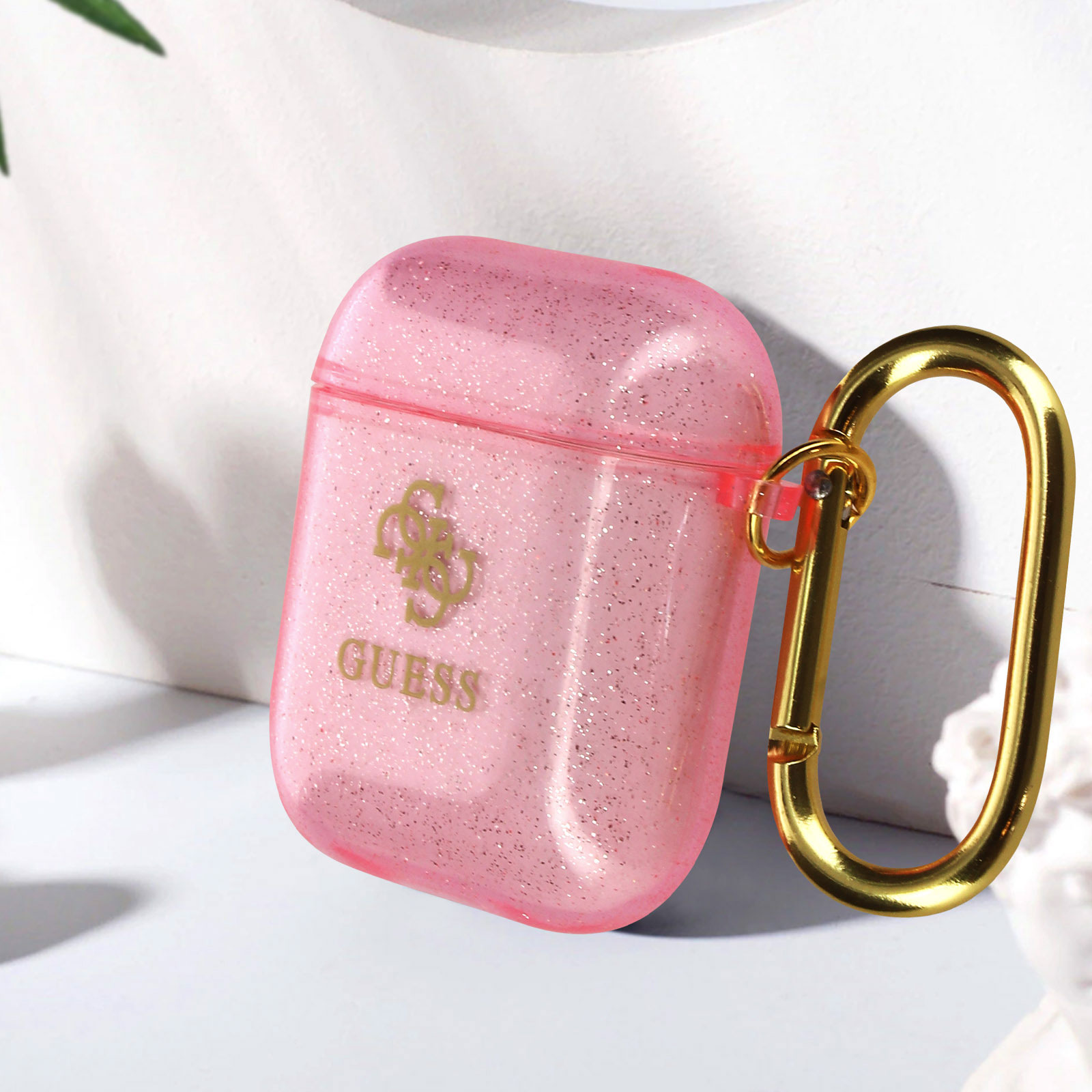 Una custodia rosa Guess AirPods con un moschettone dorato.