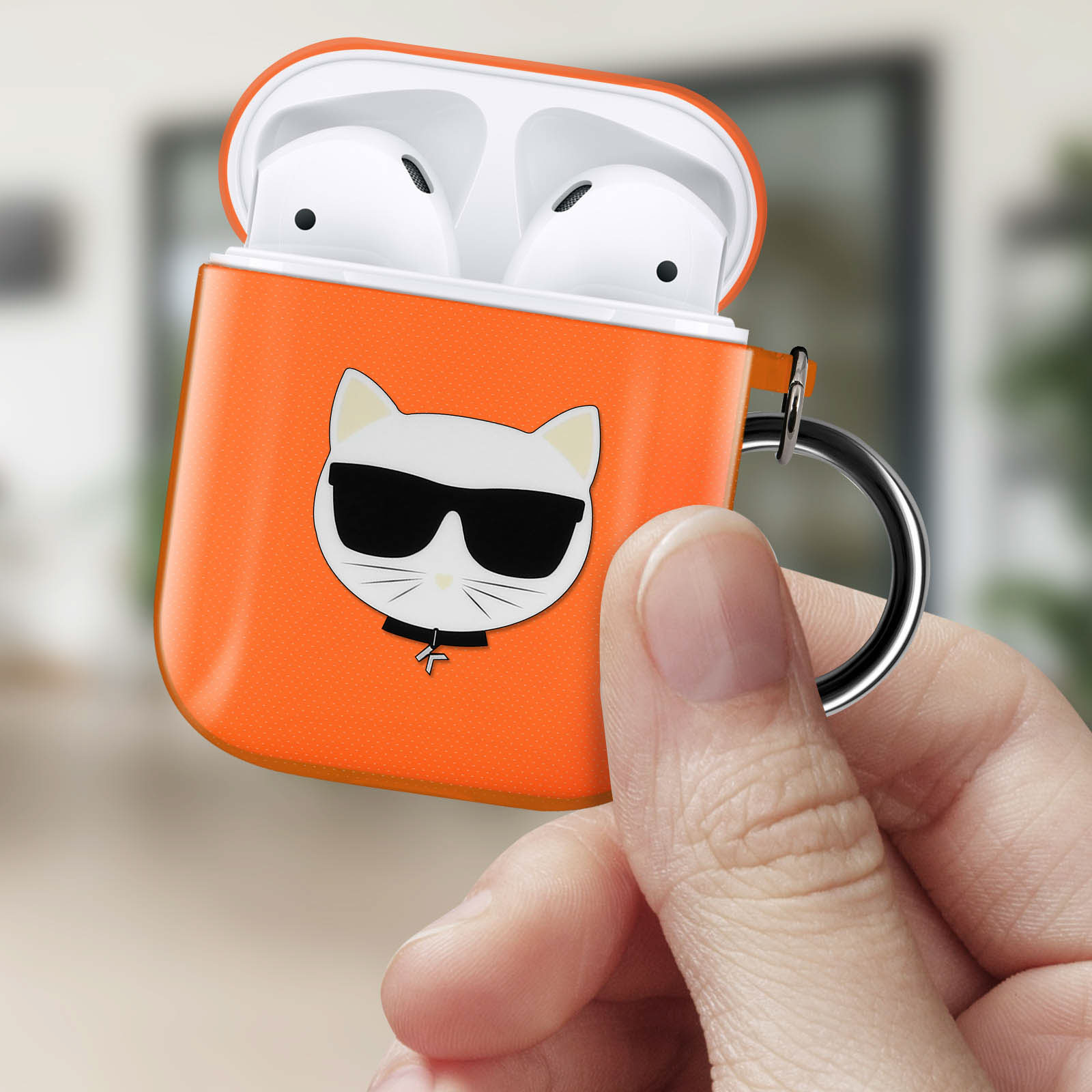Custodia arancione per AirPods con un gatto dei cartoni animati con occhiali da sole. La custodia è tenuta da una mano.