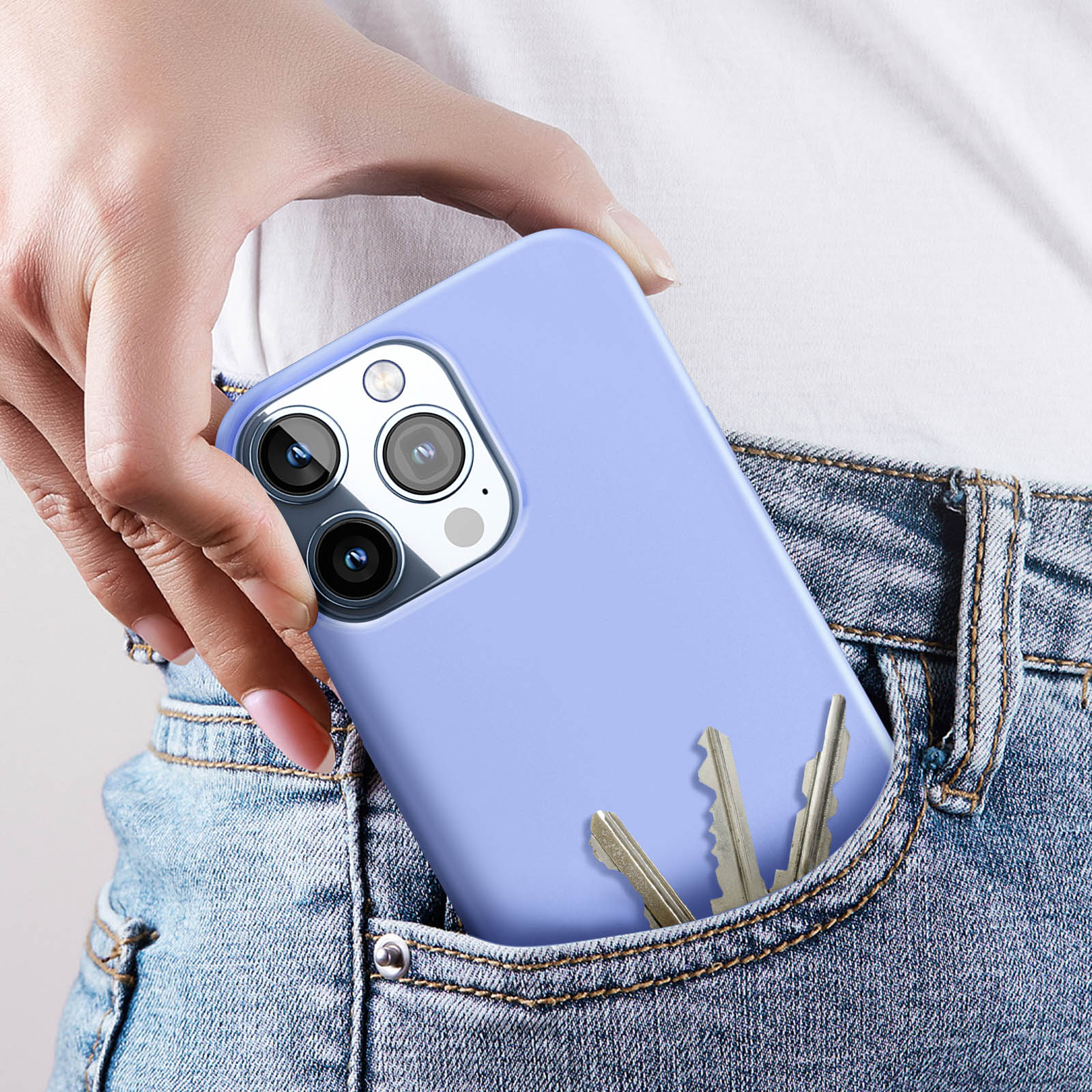 Una mano che tiene un telefono blu con chiavi in tasca. Jeans.