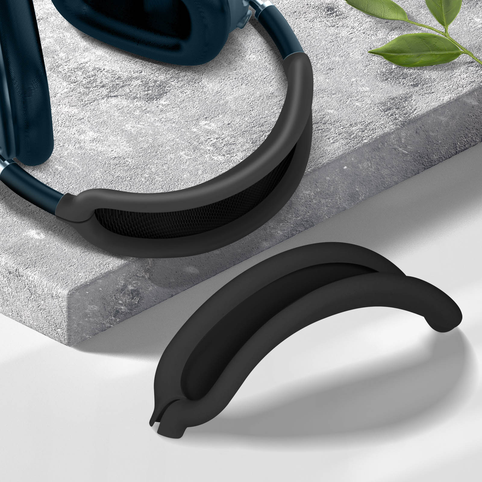 Auriculares con almohadillas negras sobre superficie gris. Una almohadilla separada debajo.
