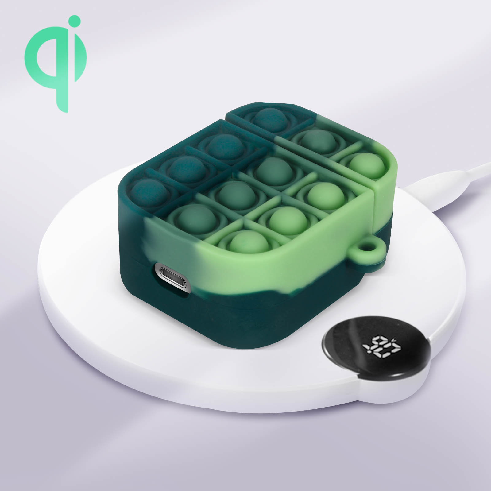 Estuche pop it verde y azul sobre un cargador inalámbrico, mostrando el estado de carga.