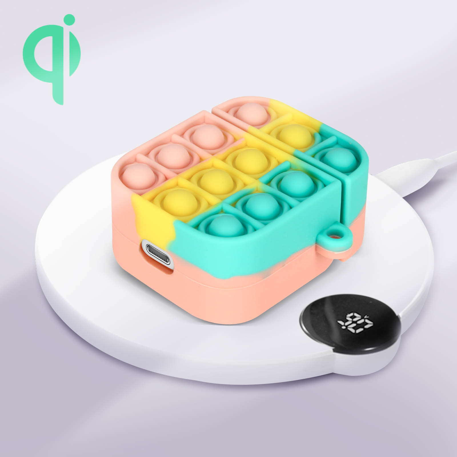 Estuche de auriculares colorido estilo Pop It en un cargador inalámbrico. Fondo blanco.