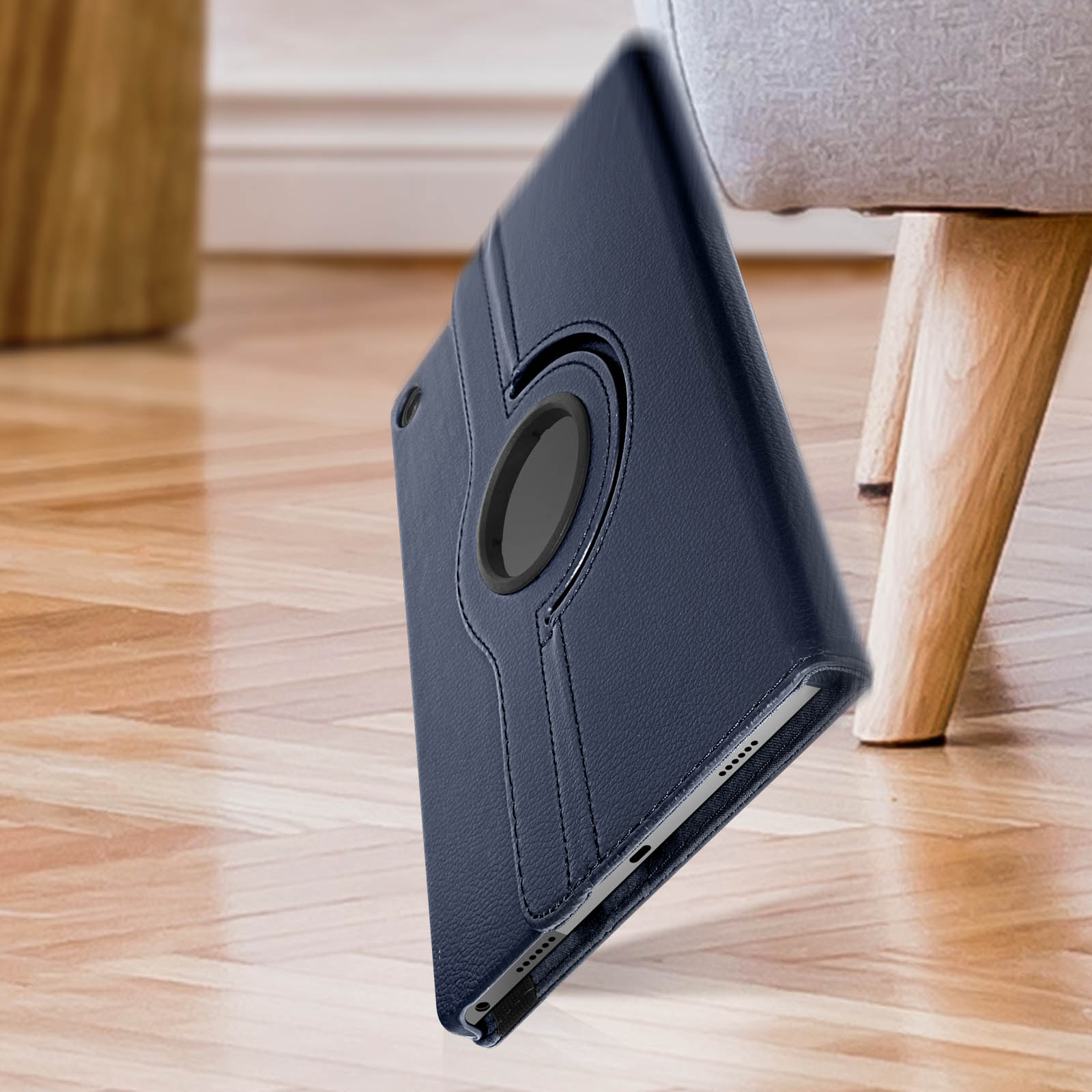 Custodia per tablet blu scuro, leggermente aperta. Con anello rotante, su gamba di legno.