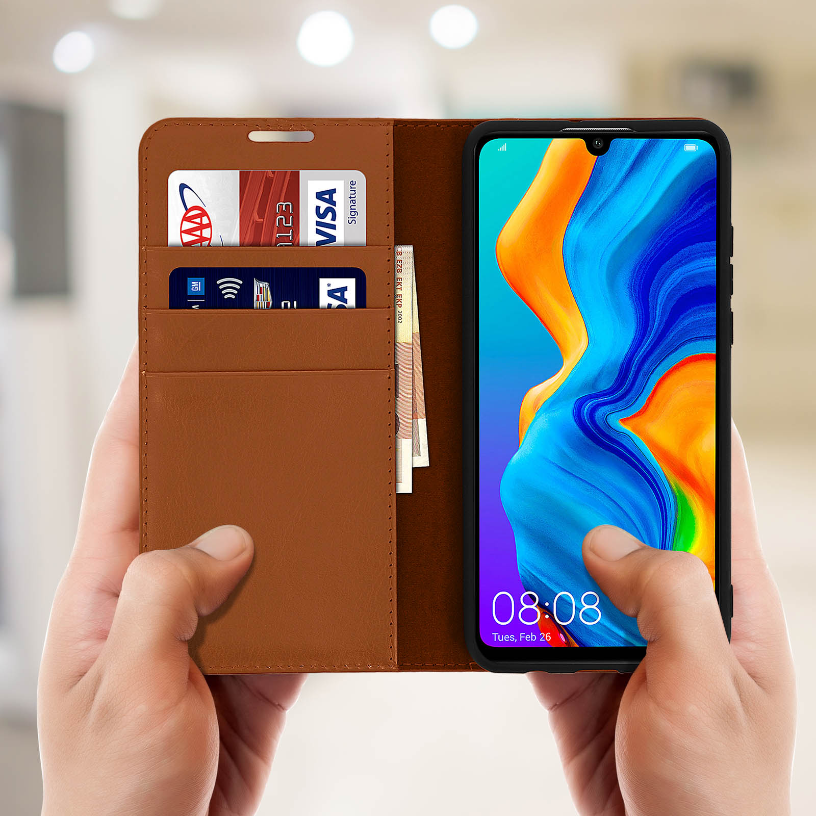 Mani che tengono una custodia marrone con un telefono all'interno, che mostra carte e denaro.
