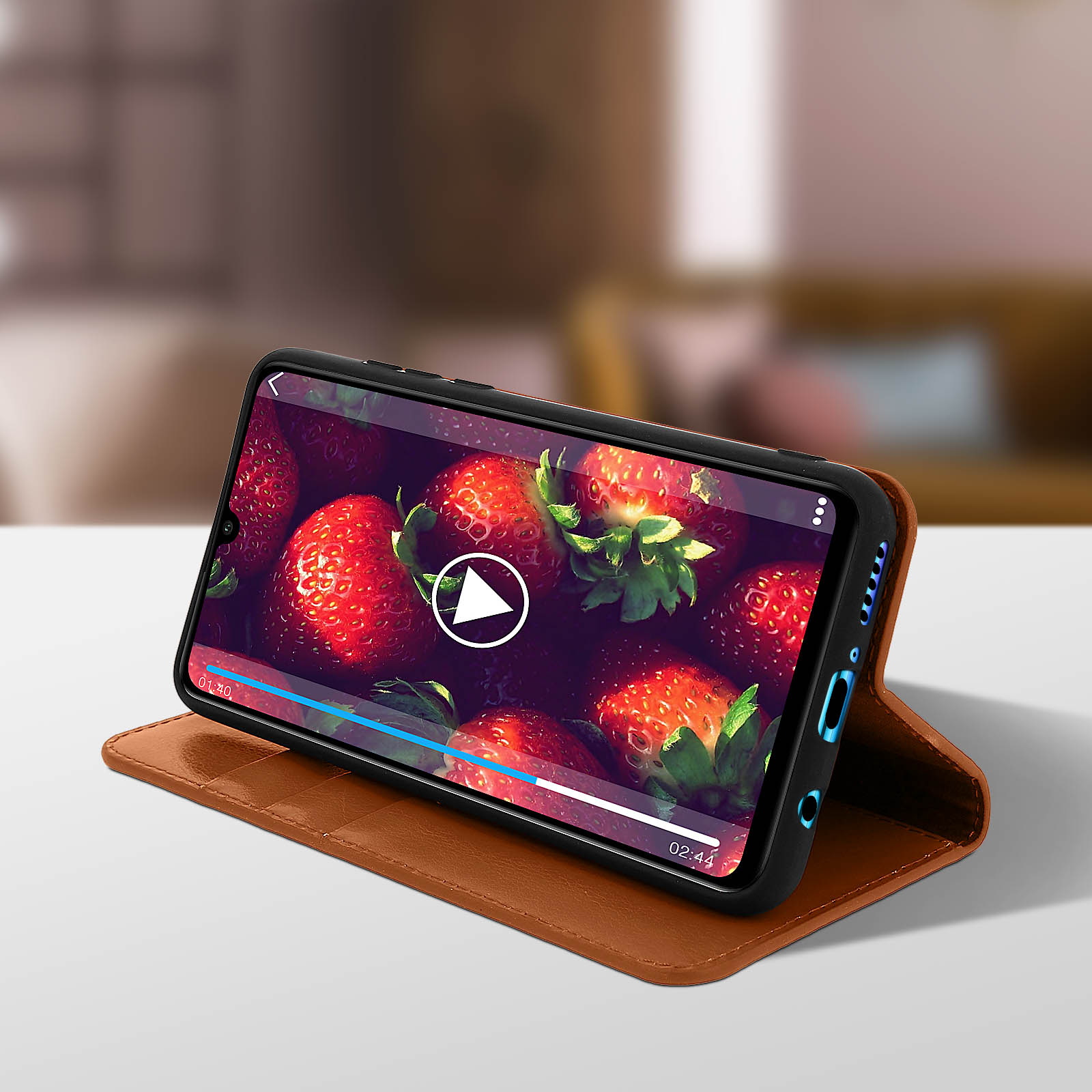 Uno smartphone in una custodia di pelle marrone che mostra un video di fragole.