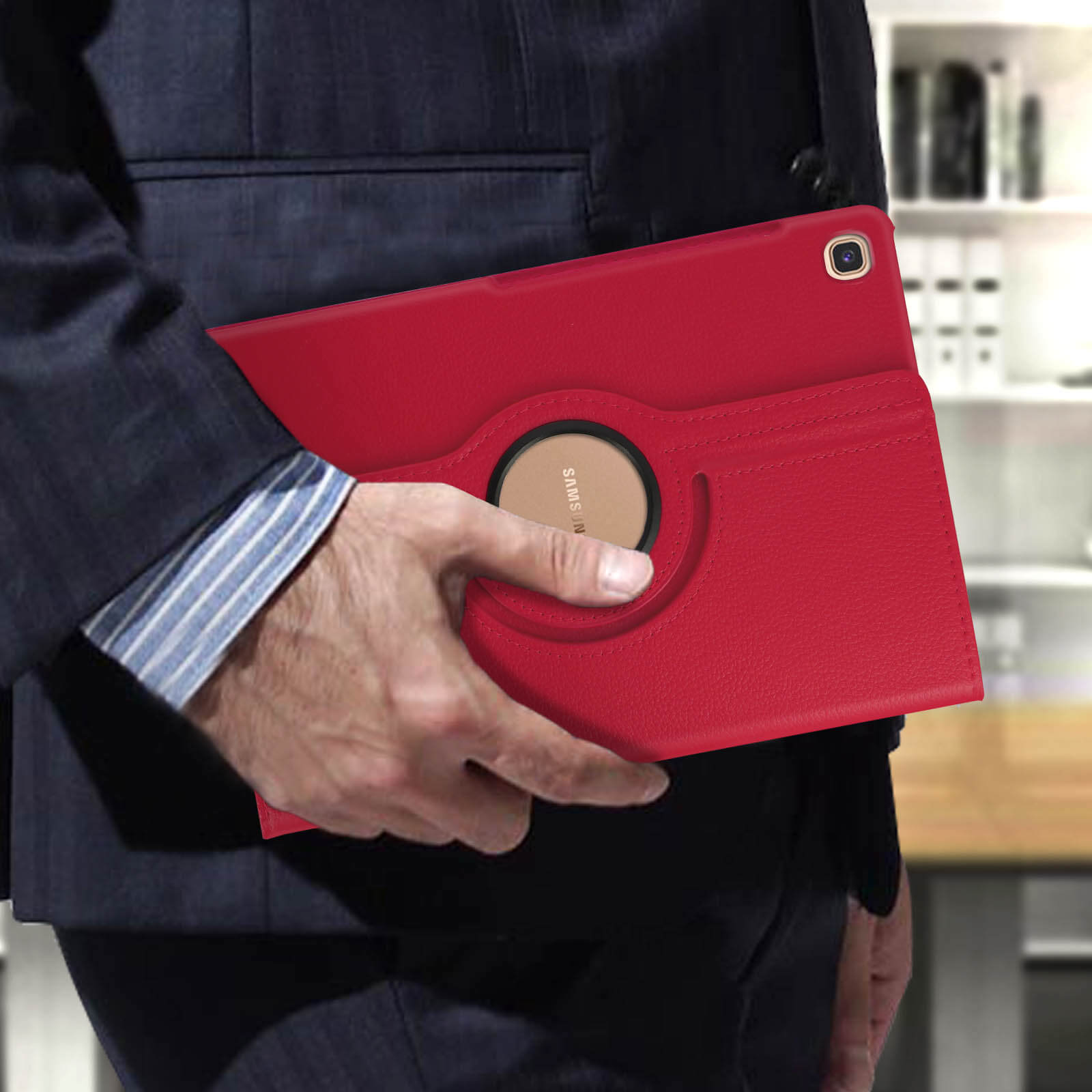 Una persona che tiene una custodia per tablet rossa, con un design circolare nero e marrone.