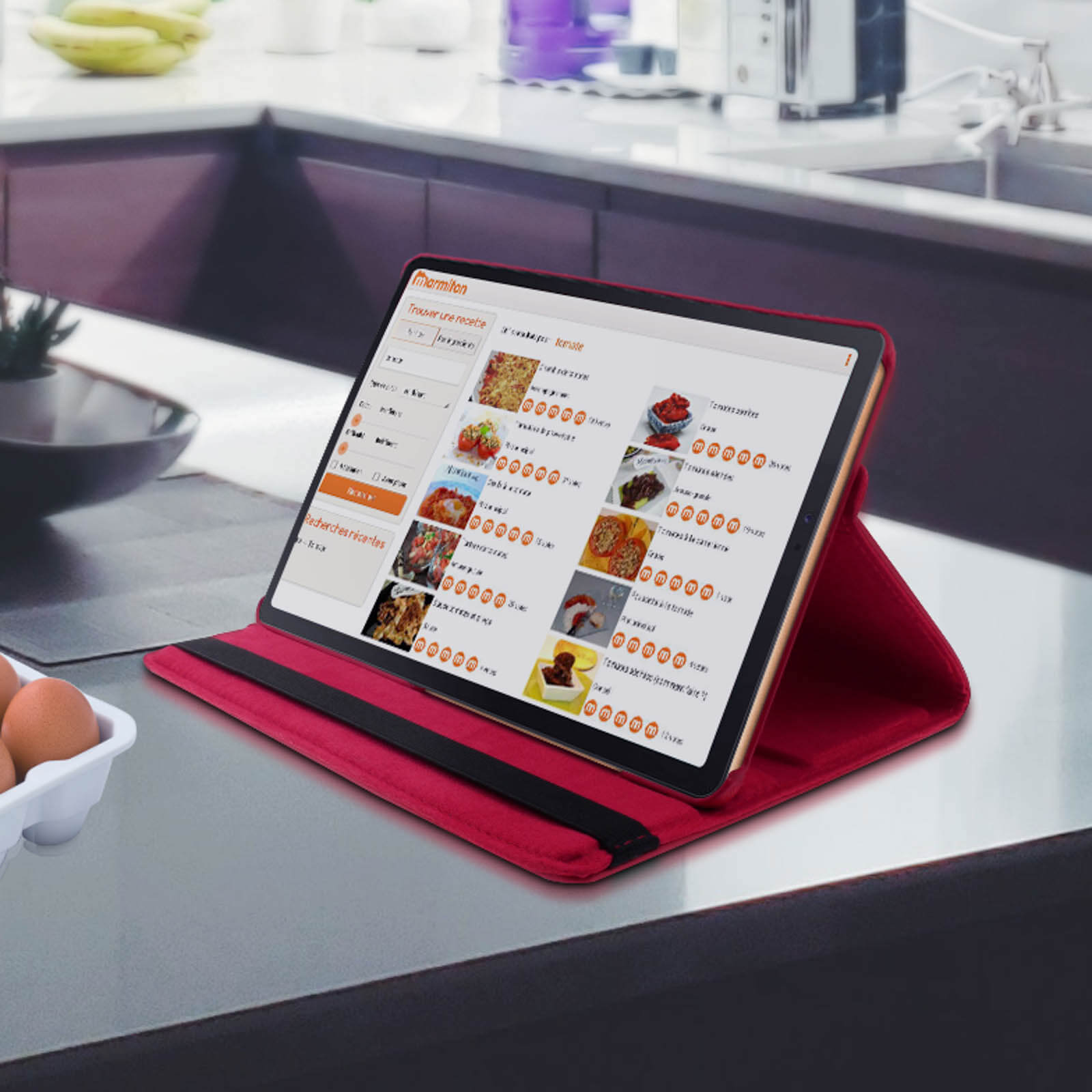Tablet con custodia rossa, angolato su un bancone. Lo schermo mostra un sito web di ricette. Cucina.