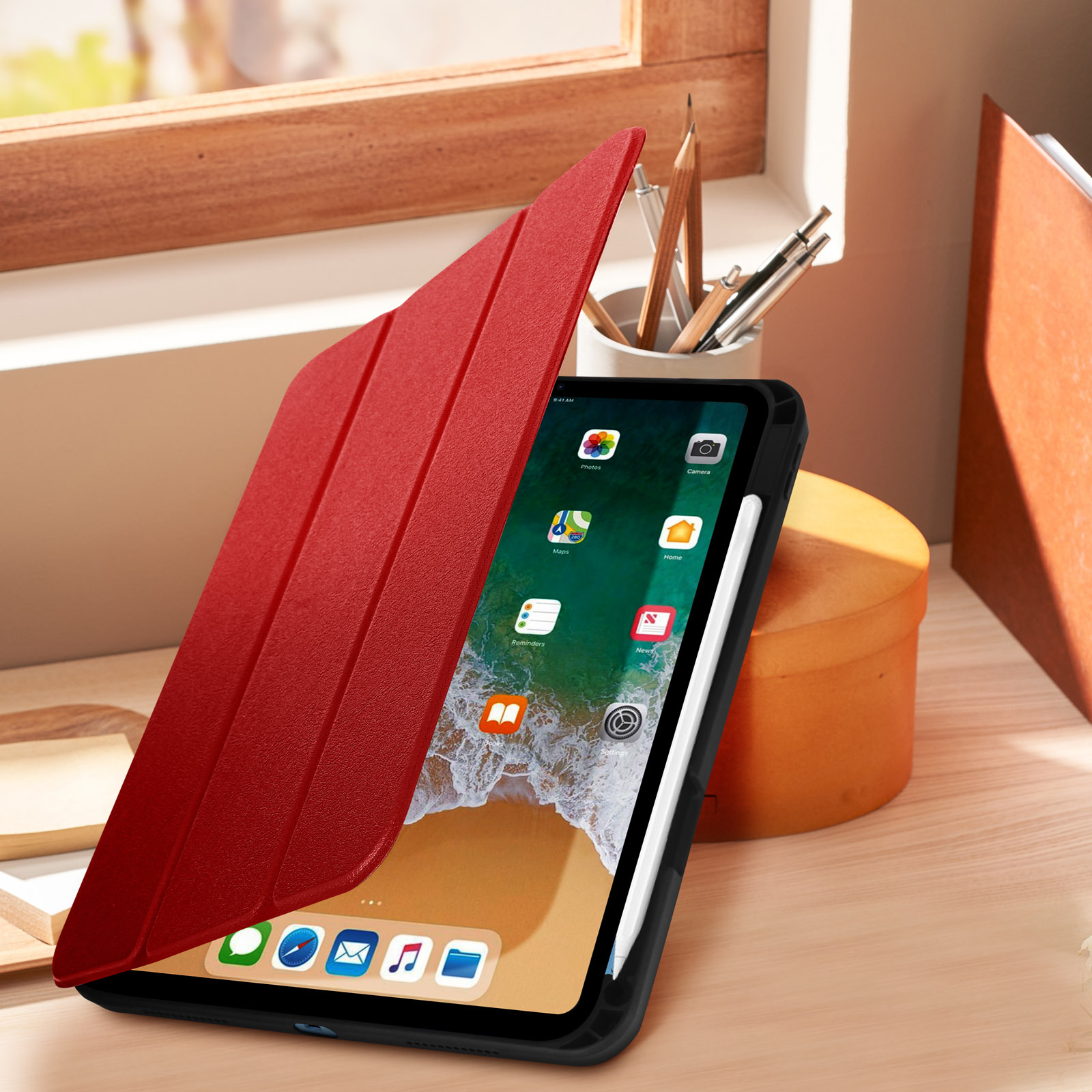 Custodia per tablet rossa aperta. Tablet mostra app, stilo e oggetti su scrivania di legno.